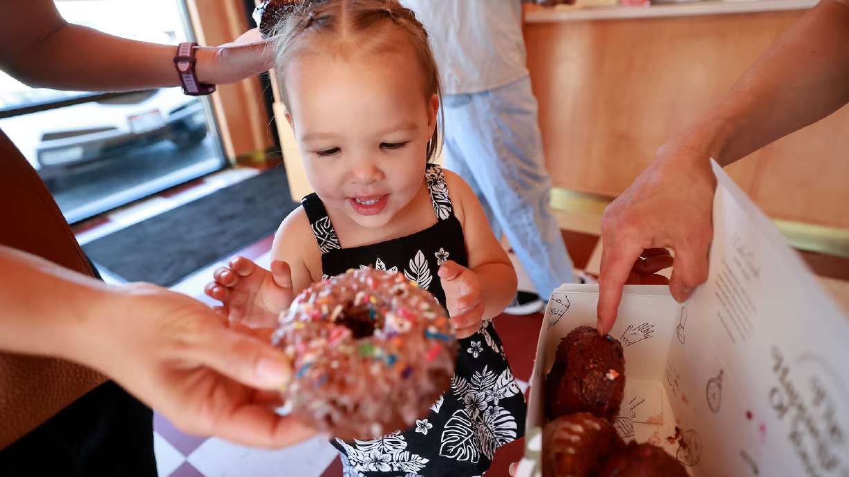 Mele Johnson, 2, looks at a Celebration Cake doughnut at Sidecar Doughnuts in Salt Lake City on Thursday. National Doughnut Day is being celebrated Friday nationwide.