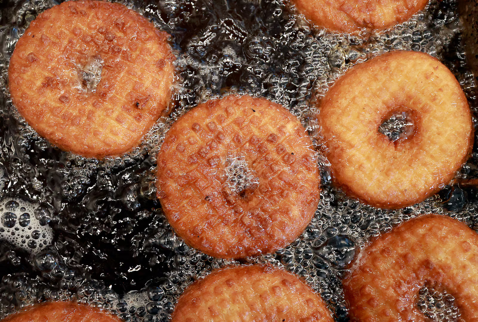 Doughnuts float in a fryer at Sidecar Doughnuts in Salt Lake City on Thursday. National Doughnut Day is being celebrated Friday nationwide.