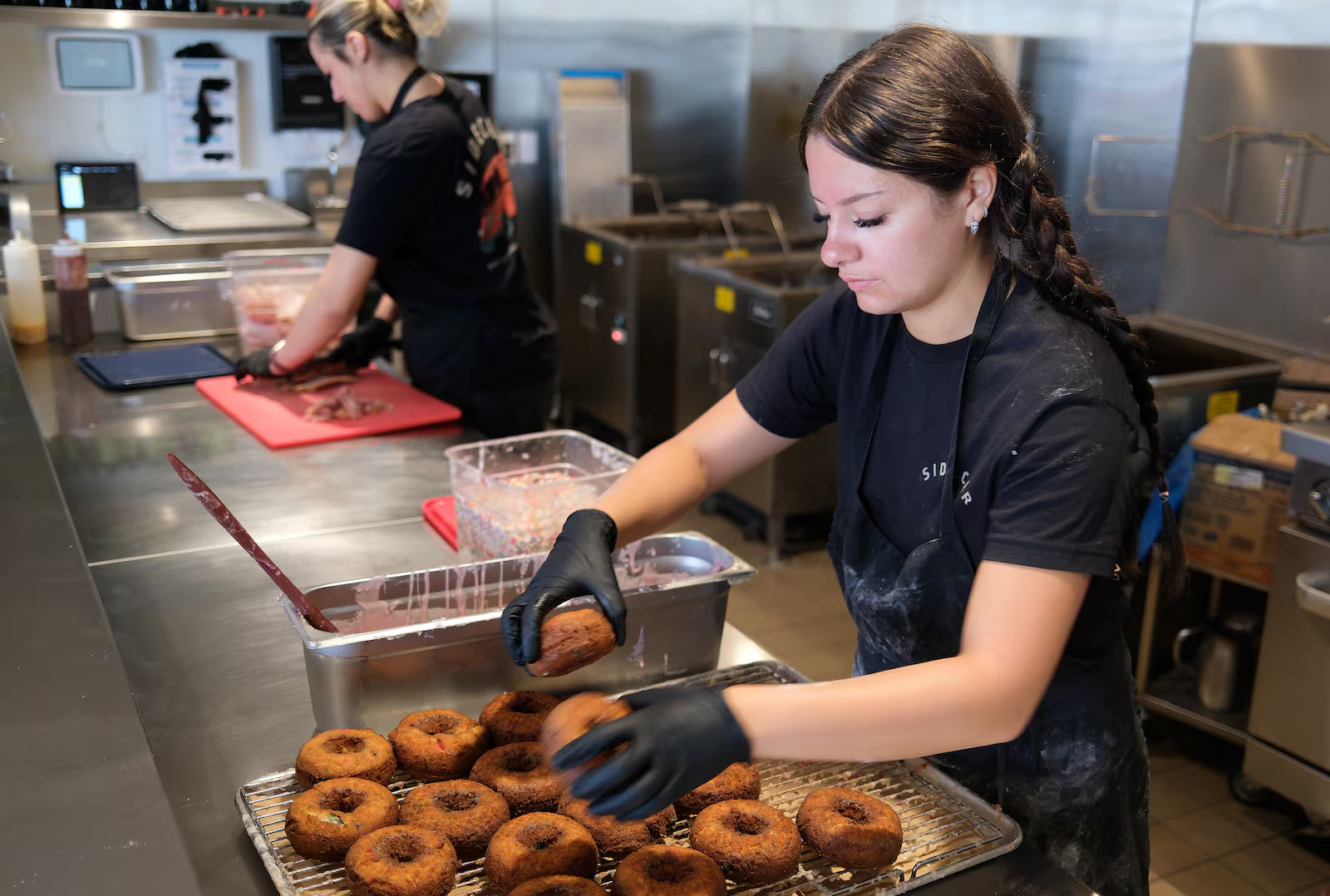 Jackie Sullivan, Sidecar Doughnuts assistant manager, makes doughnuts at the shop on Thursday. National Donut Day is being celebrated nationwide on Friday, and Sidecar is joining in the fun.