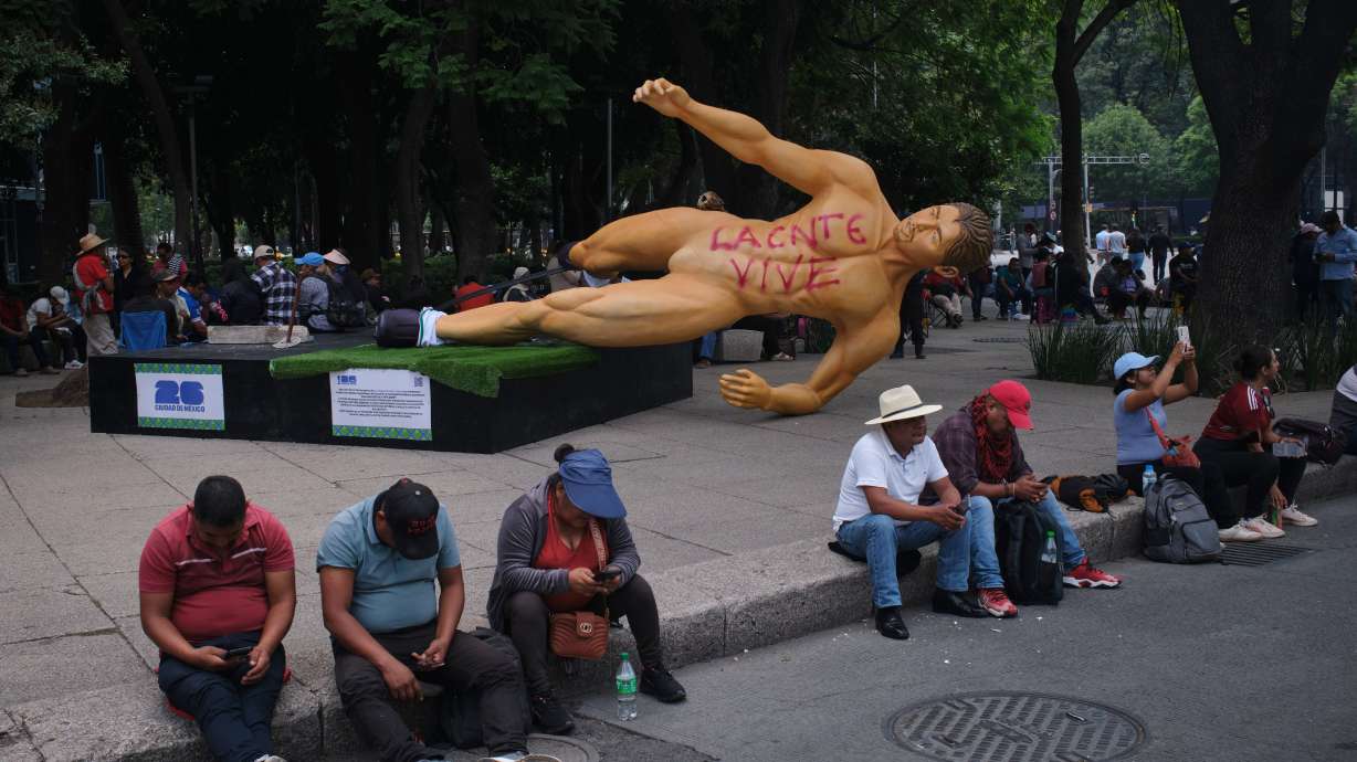 A World Cup statue, with graffiti that reads in Spanish, "The National Educational Workers Coordination lives" lies sideways during a teachers' protest for higher salaries sit in Mexico City, Tuesday, June 2, 2026.