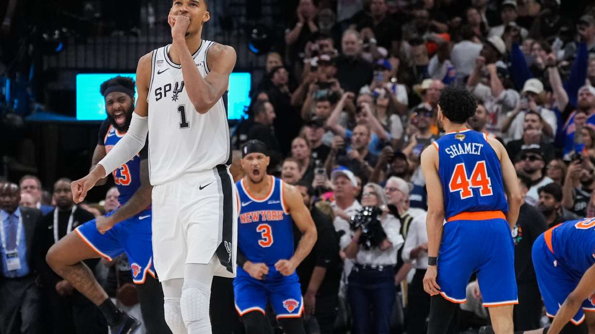 San Antonio Spurs forward Victor Wembanyama walks off the court as time expires during the second half of Game 2 of the NBA Finals basketball series as New York Knicks guard Landry Shamet (44), guard Josh Hart (3), and center Mitchell Robinson (23) celebrate, Friday, June 5, 2026, in San Antonio.