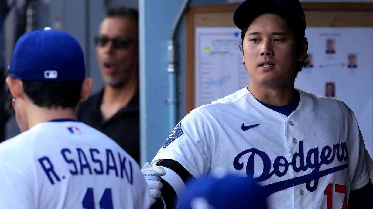 Los Angeles Dodgers starting pitcher Roki Sasaki, left, greets Shohei Ohtani I. The dugout prior to a baseball game against the Los Angeles Angels, Friday, June 5, 2026, in Los Angeles.