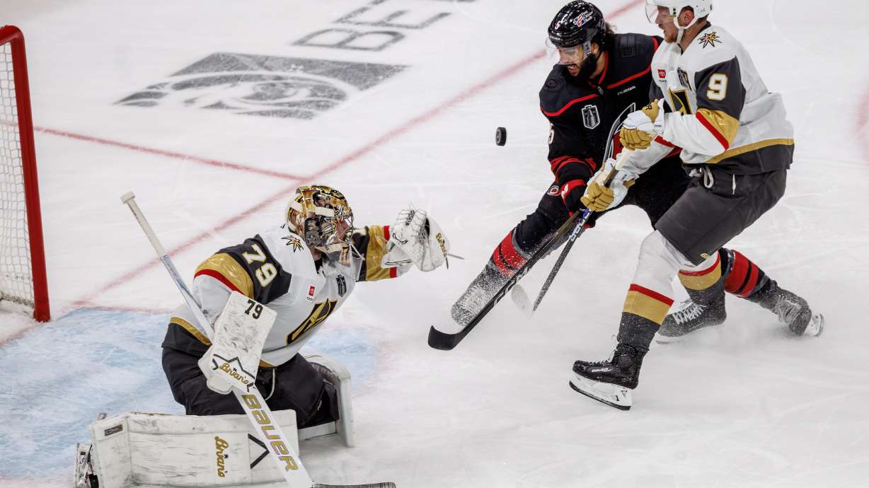 Vegas Golden Knights' Carter Hart (79) knocks a puck away from the net as Golden Knights' Jack Eichel (9) and Carolina Hurricanes' Jalen Chatfield (5) battle during the second period of Game 2 of the NHL hockey Stanley Cup Final series in Raleigh, N.C., Thursday, June 4, 2026.