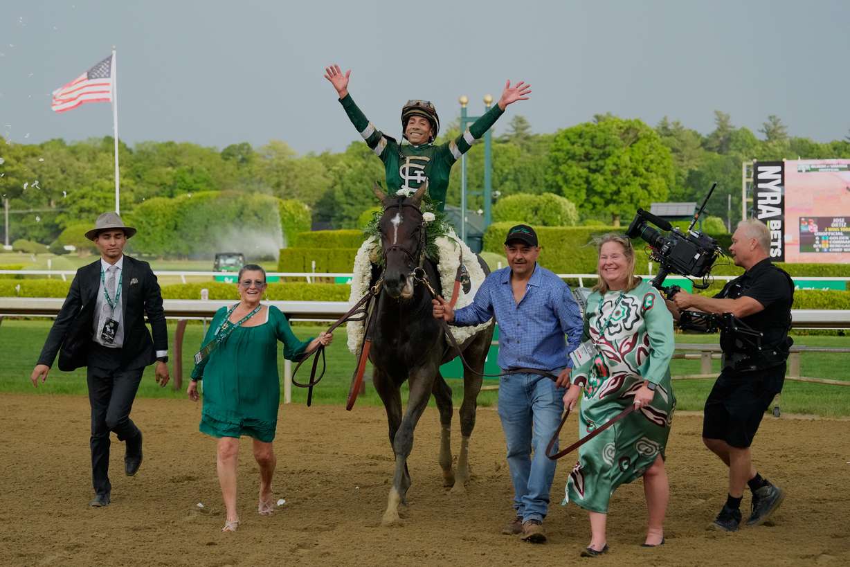 Jockey Jose Ortiz celebrates aboard Golden Tempo as they are led to the winner's circle after winning the 158th running of the Belmont Stakes horse race, Saturday, June 6, 2026, in Saratoga Springs, N.Y.