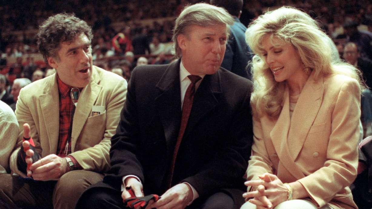 FILE - Actor Elliott Gould, left, joins Donald Trump, center, and Marla Maples at courtside during an NBA basketball game between the Phoenix Suns and the New York Knicks at Madison Square Garden, in New York, March 6, 1991.