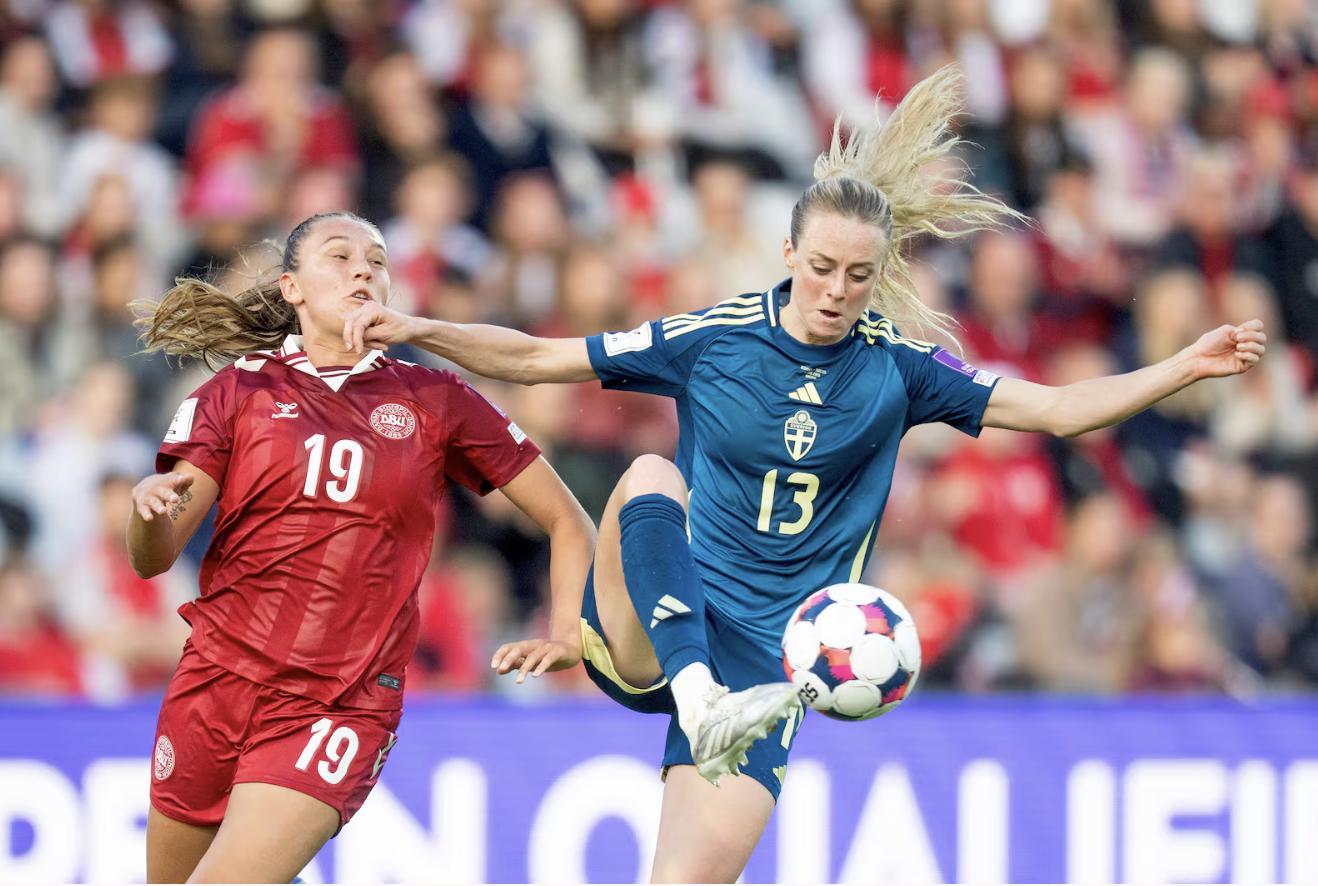 Sweden's Amanda Ilestedt, right, controls the ball as Denmark's Cecilie Floee closes in during the World Cup qualifying match between Denmark and Sweden, Friday, in Odense, Denmark.