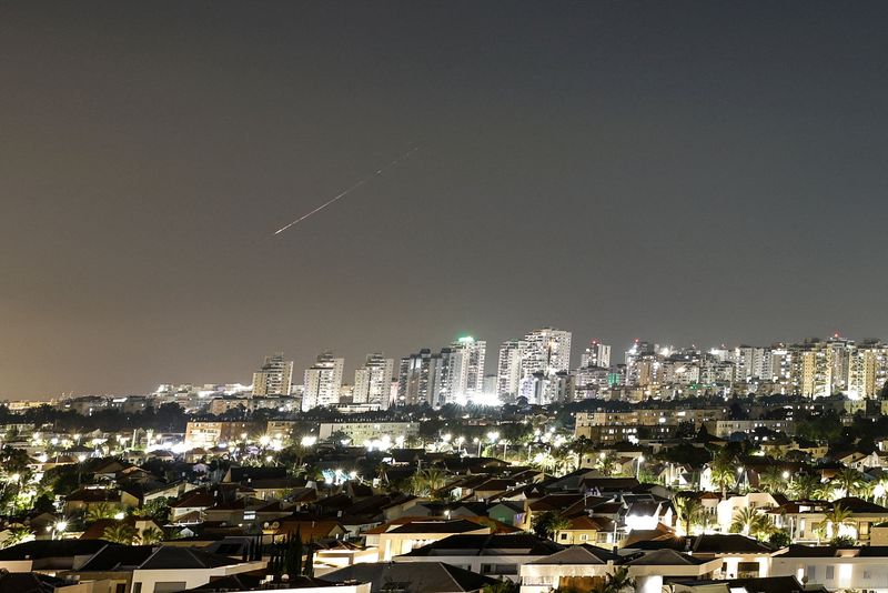 A streak of light illuminates the sky during a missile attack from Iran towards Israel as seen from Ashkelon, Israel, Sunday.