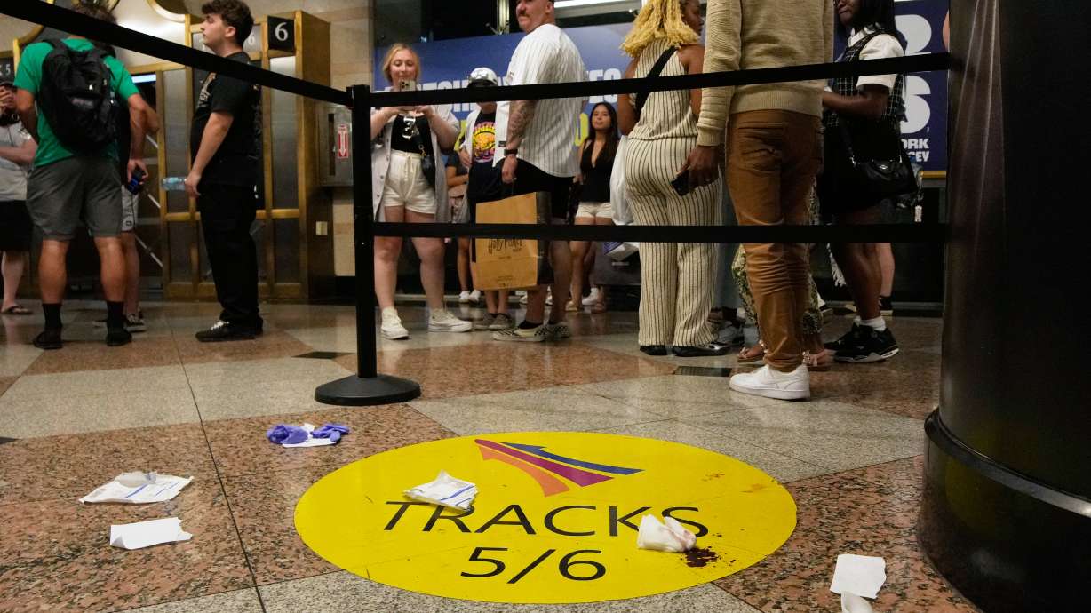 People stand near an area roped off after a stabbing at Penn Station on Sunday, June 7, 2026, in New York.