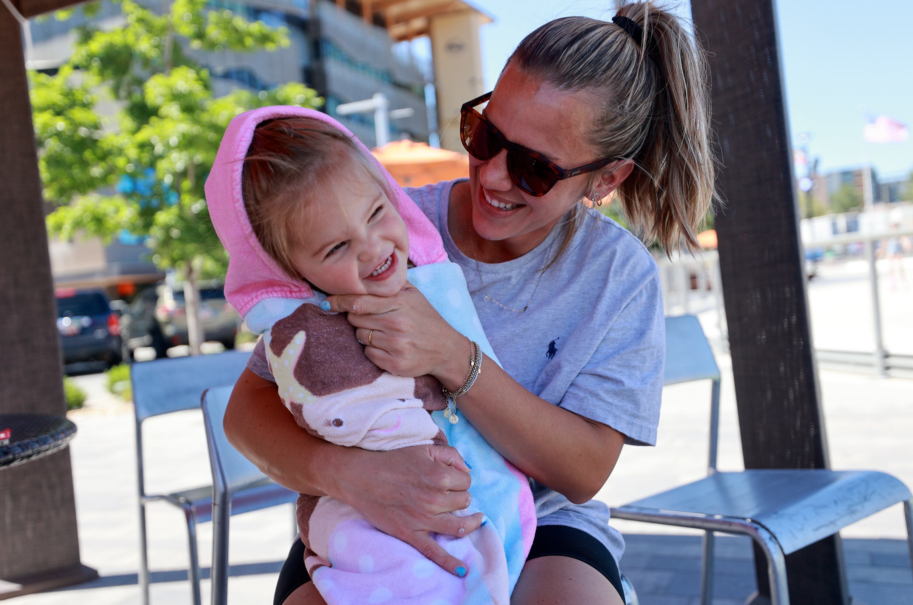 Hanna Matekel hugs her daughter Scottie Matekel, 2, while taking a break from the water at the Millcreek Common splash pad in Millcreek on Thursday. The state is starting a new initiative to encourage parents to foster close relationships with their children.