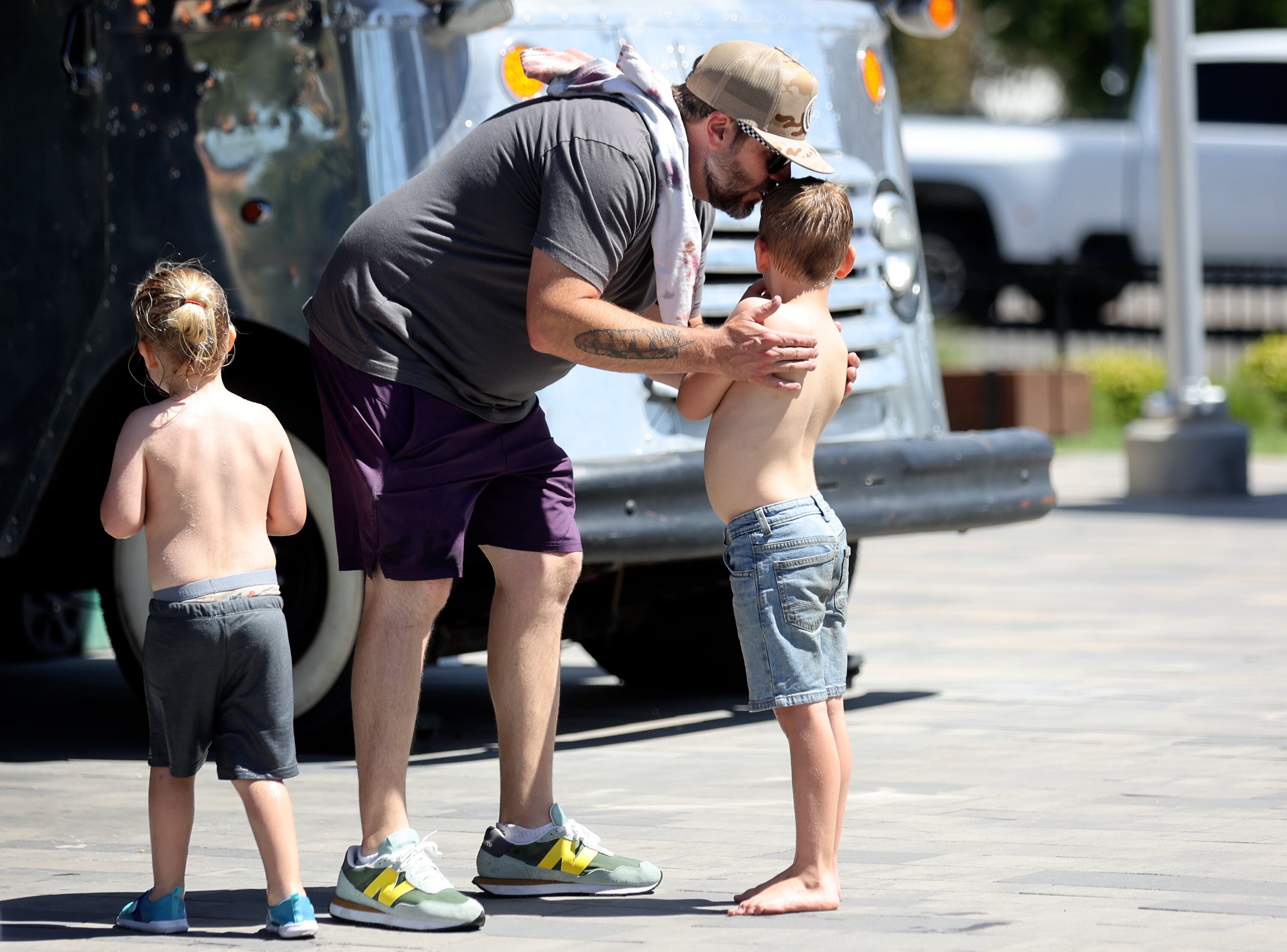 Johnny Murdock gathers his sons to leave after playing at the Millcreek Common splash pad in Millcreek on Thursday. The state is starting a new initiative to encourage parents to foster close relationships with their children.