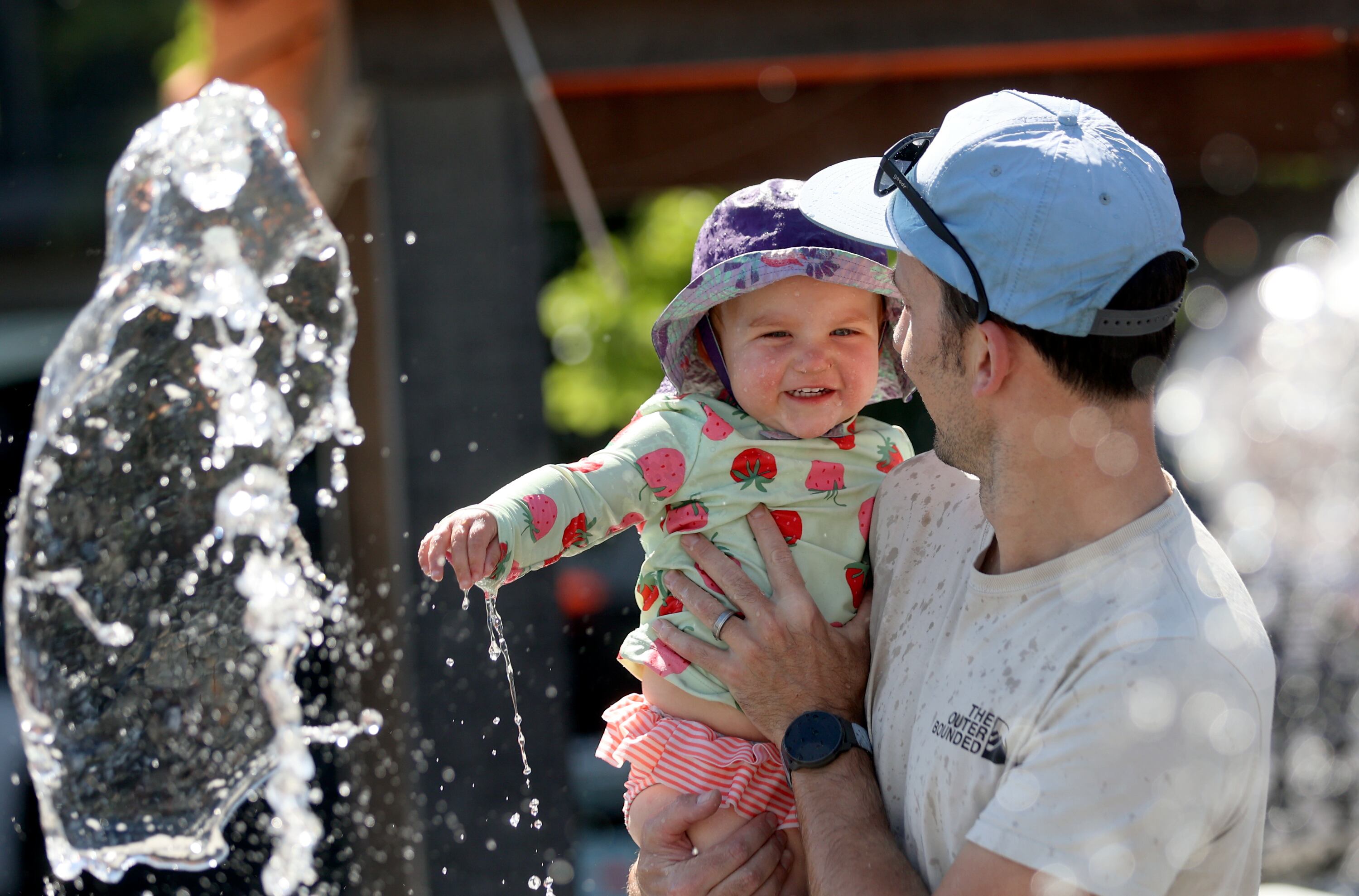 Andrew West holds Eleanor West as they play at the Millcreek Common splash pad in Millcreek on Thursday. Aimee Winder Newton of Utah's Office of Families said benefits of building relationships are more than sitting at the dinner table and talking.