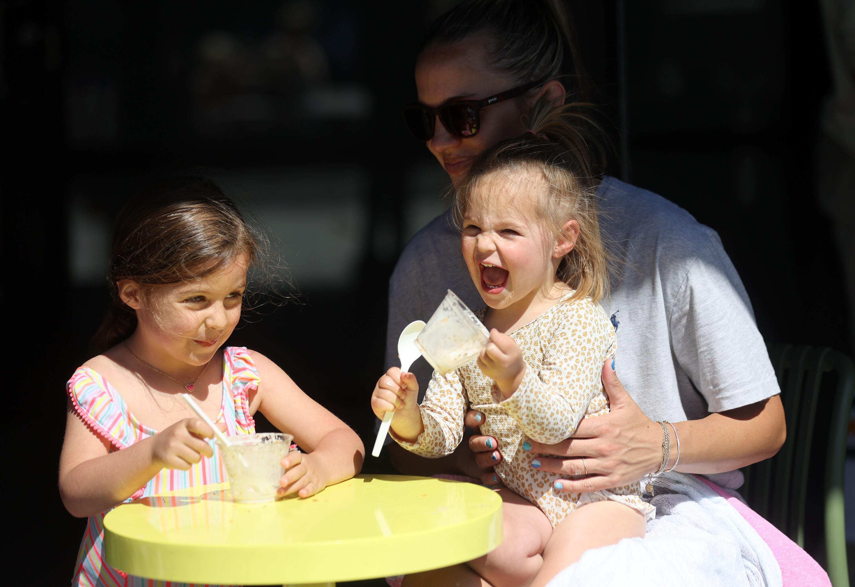 Remi Matekel and Scottie Matekel giggle over ice cream with their mother Hanna Matekel at Millcreek Common in Millcreek on Thursday. Matekel said she loves being with her kids to help build close relationships.