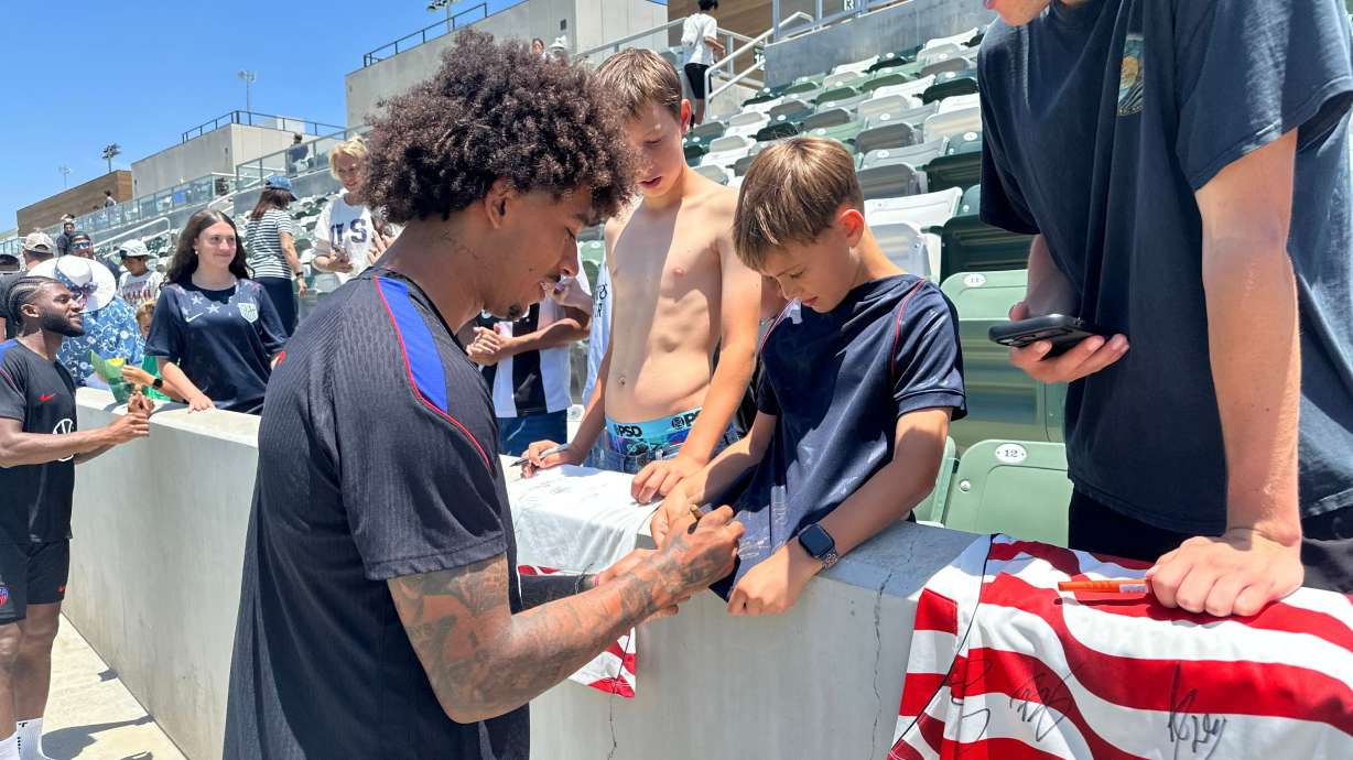 United States defender Chris Richards, front left, gives autographs to fans after the nationall team's first practice at its World Cup soccer tournament training base in Irvine, Calif., Monday, June 8, 2026.