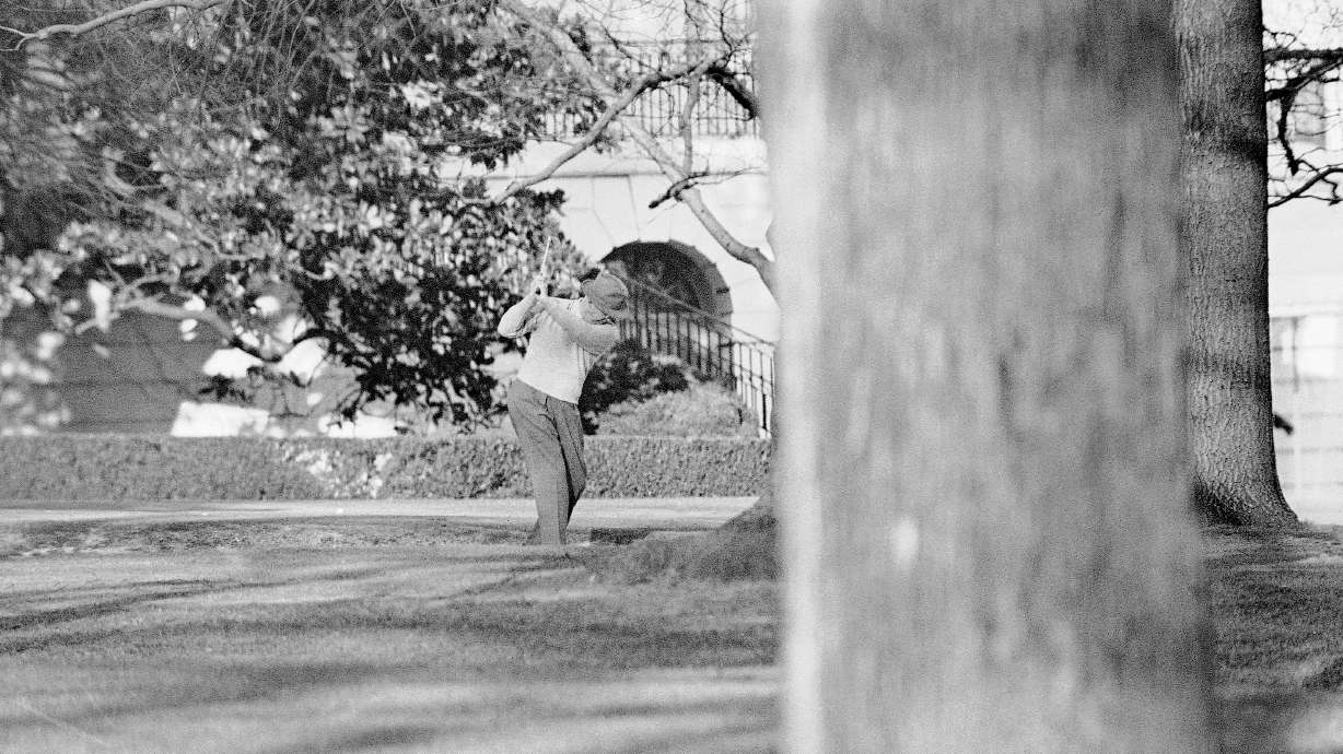 FILE - President Dwight Eisenhower brushes up on his golf game near the putting green on the lawn of the White House, Jan. 13, 1959, in Washington.