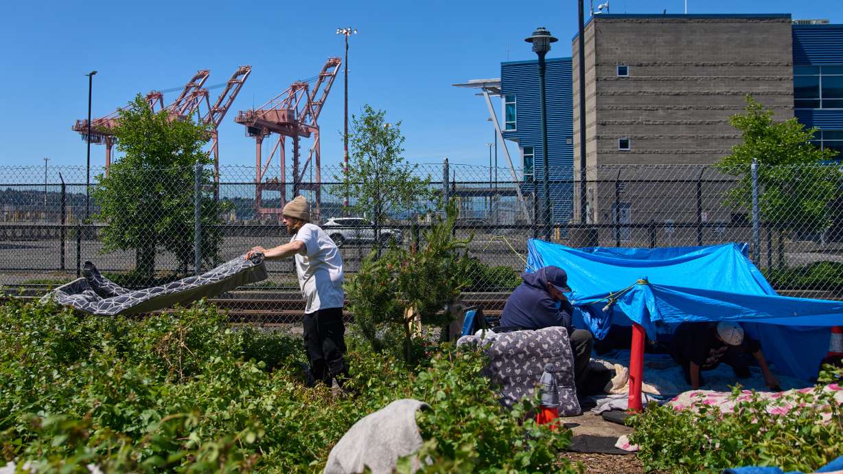 Chris Moore airs out blankets that got wet during the previous day's rain at his makeshift tent near Seattle Stadium, ahead of the 2026 FIFA World Cup soccer matches Wednesday, May 27, 2026, in Seattle.
