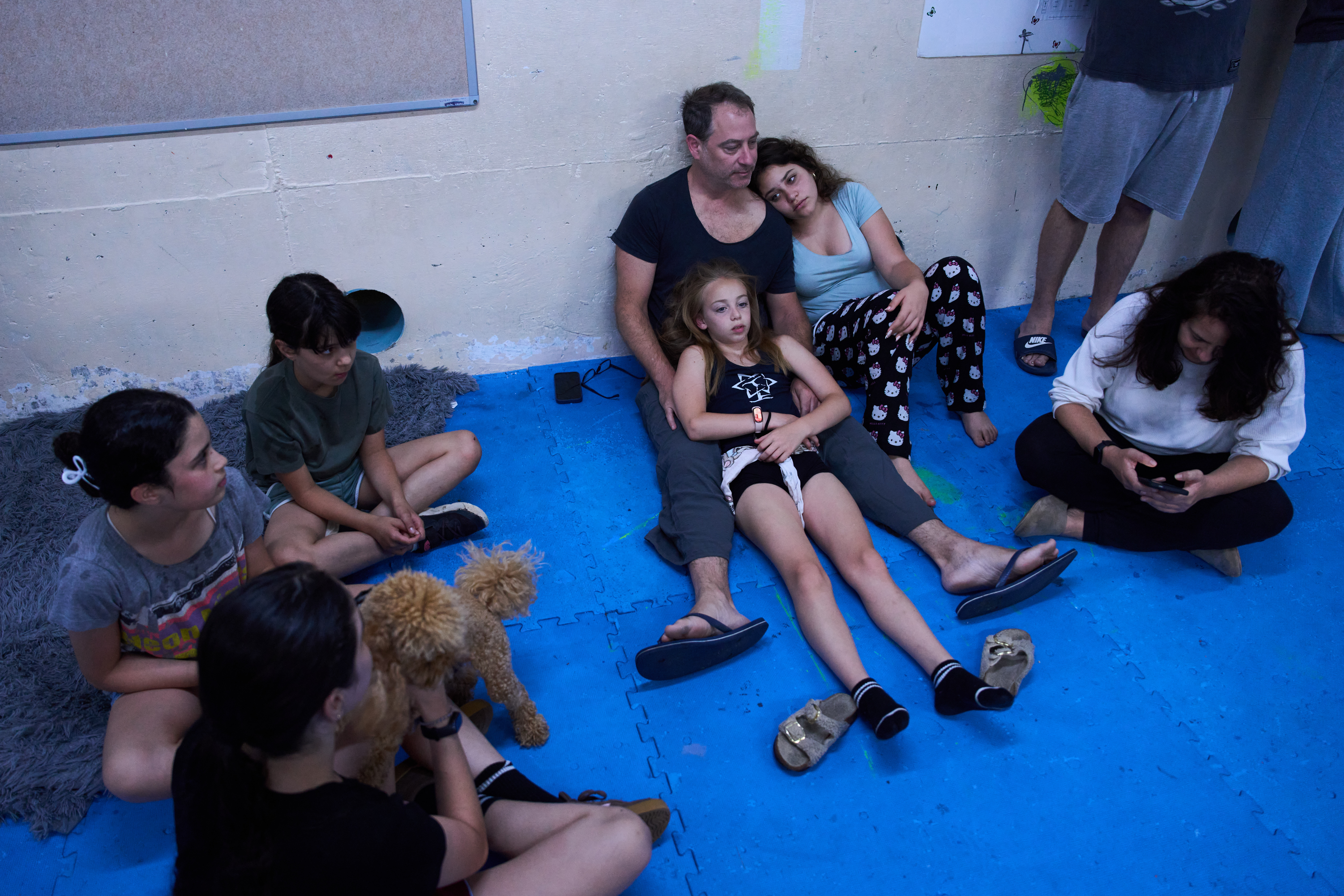 People take shelter as air raid sirens warn of incoming Iranian missiles in Ramat Gan, Israel, Monday. Both the U.S. and Iran launched airstrikes on the other after President Donald Trump blamed Tehran for downing an Army helicopter.