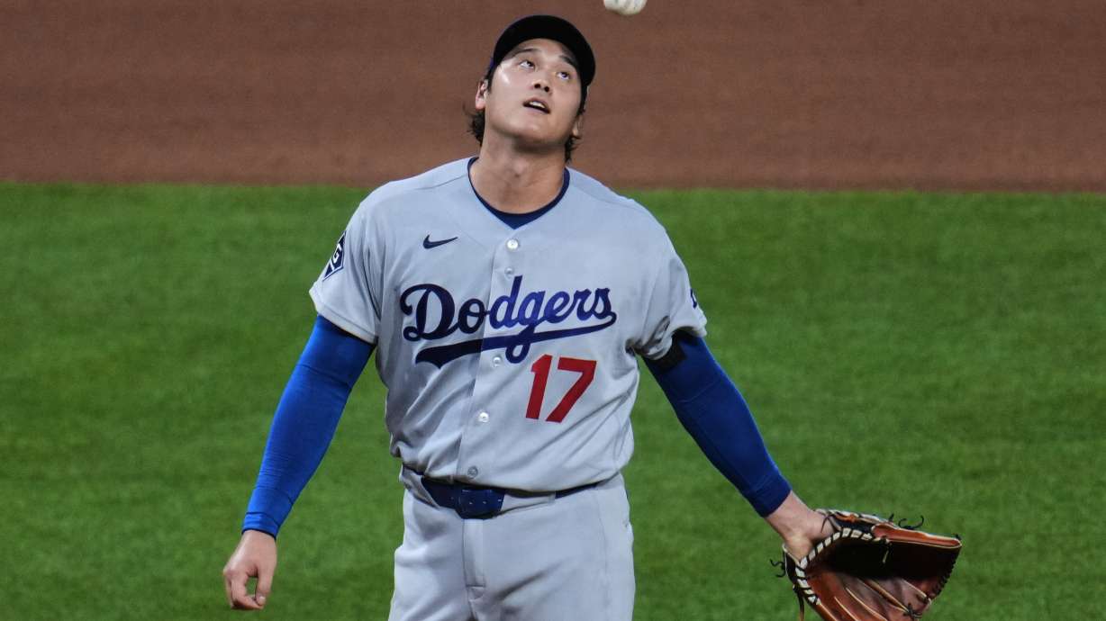 Los Angeles Dodgers two-way player Shohei Ohtani waits to hand the ball to manager Dave Roberts, after giving up a two-run double to Pittsburgh Pirates' Brandon Lowe during the seventh inning of a baseball game in Pittsburgh, Wednesday, June 10, 2026.