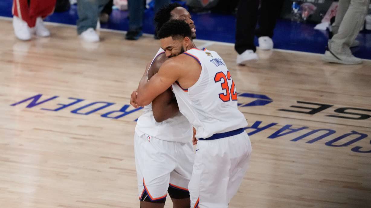 New York Knicks center Karl-Anthony Towns (32) embraces forward Og Anunoby after Game 4 of the NBA Finals basketball series against the San Antonio Spurs, Wednesday, June 10, 2026, in New York.