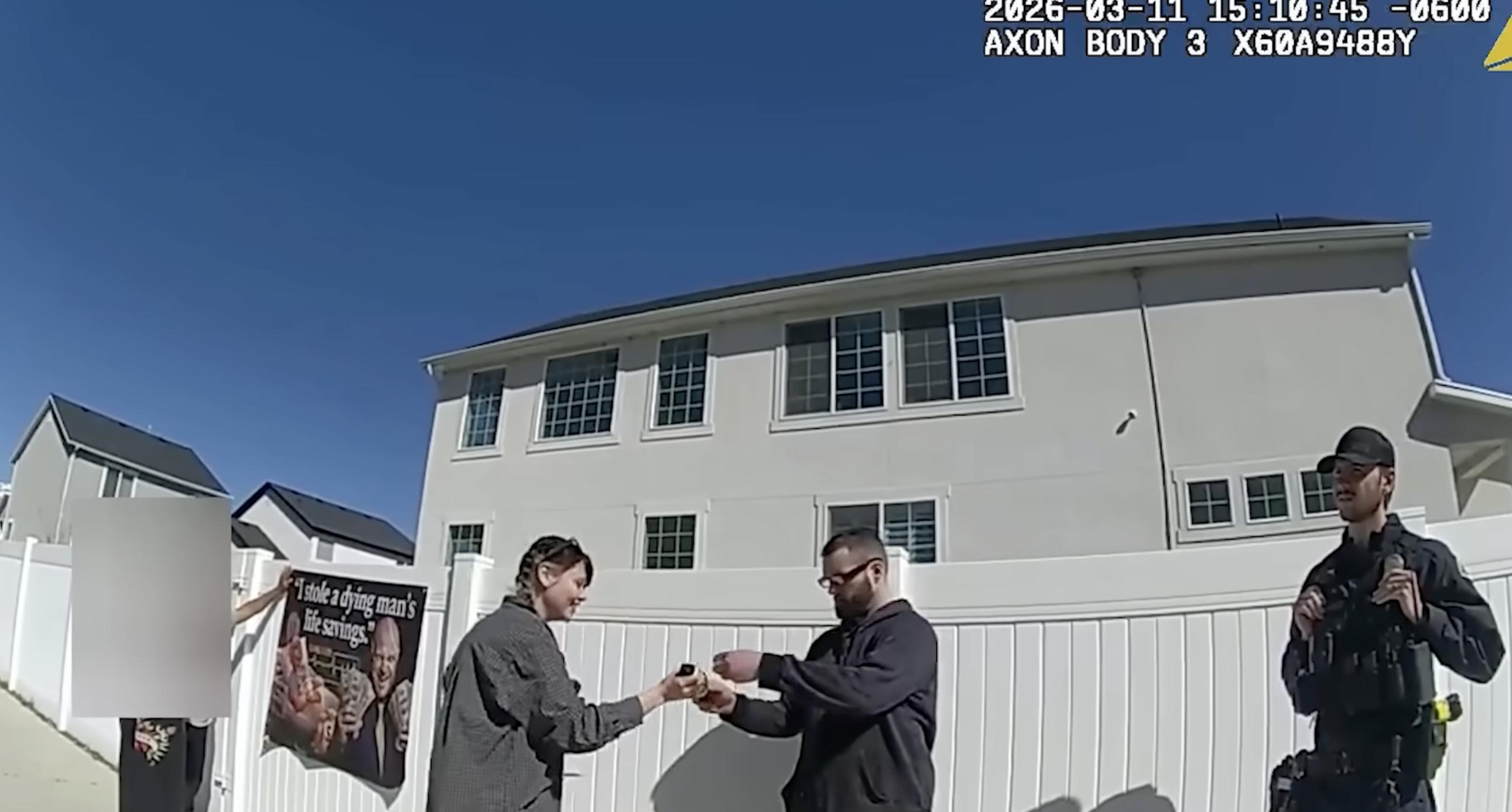 Body camera footage shows people associated with Benjamin Schneider hanging up a sign advertising a GoFundMe.