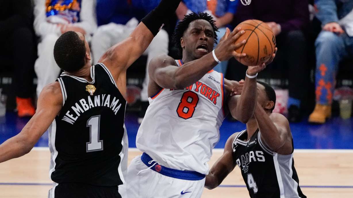 New York Knicks forward Og Anunoby (8) shoots between San Antonio Spurs forward Victor Wembanyama (1) and guard De'aaron Fox (4) during the first half of Game 4 of the NBA Finals basketball series, Wednesday, June 10, 2026, in New York.