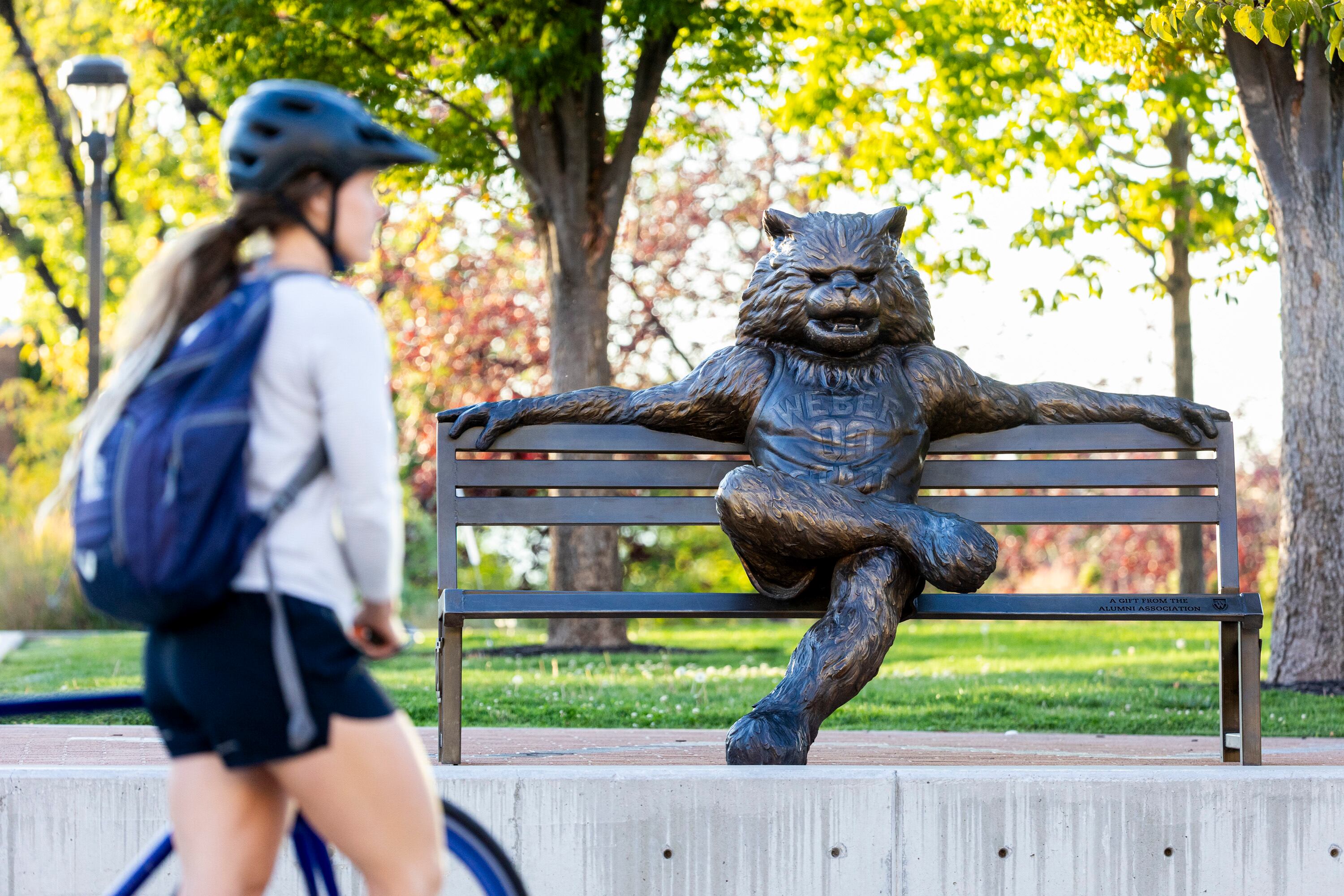 A student walks their bike past a statue of Waldo the Wildcat on the campus of Weber State University in Ogden on Oct. 1. A bill to crack down on "ghost students" sponsored by Rep. Burgess Owens passed the House on Thursday.
