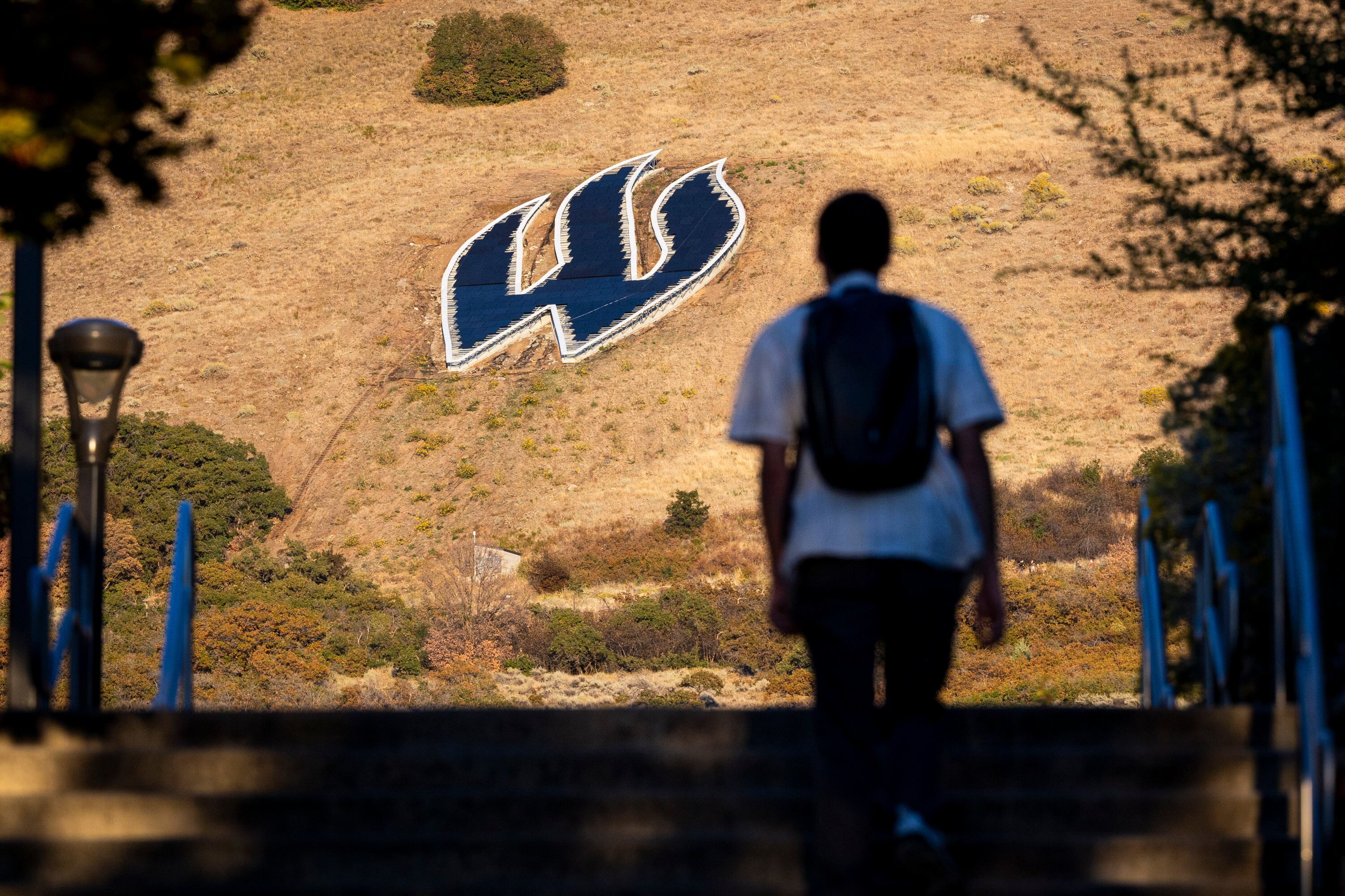 A student walks toward the “W” on the mountainside near the campus of Weber State University in Ogden on Oct. 1. The school asked for slight timing modifications to its strategic reinvestment implementation on Thursday.