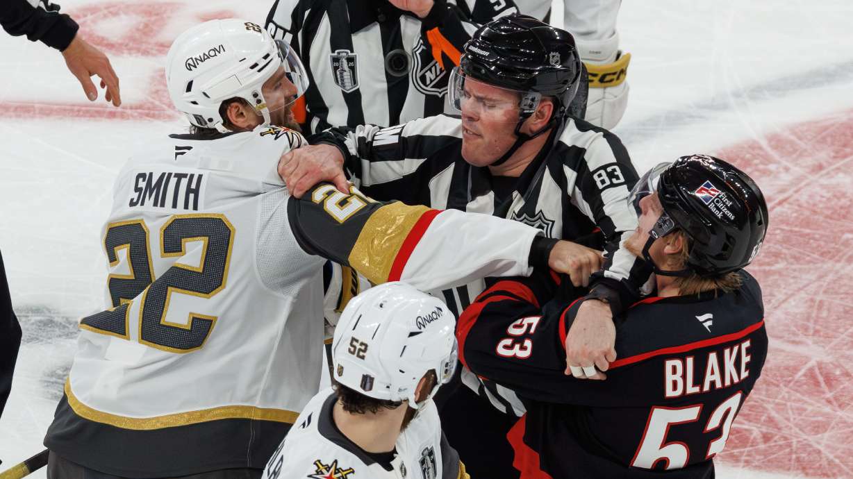 Vegas Golden Knights' Cole Smith (22) and Carolina Hurricanes' Jackson Blake (53) scuffle as an official tries to separate them during the second period of Game 5 of the NHL hockey Stanley Cup Final series in Raleigh, N.C., Thursday, June 11, 2026.