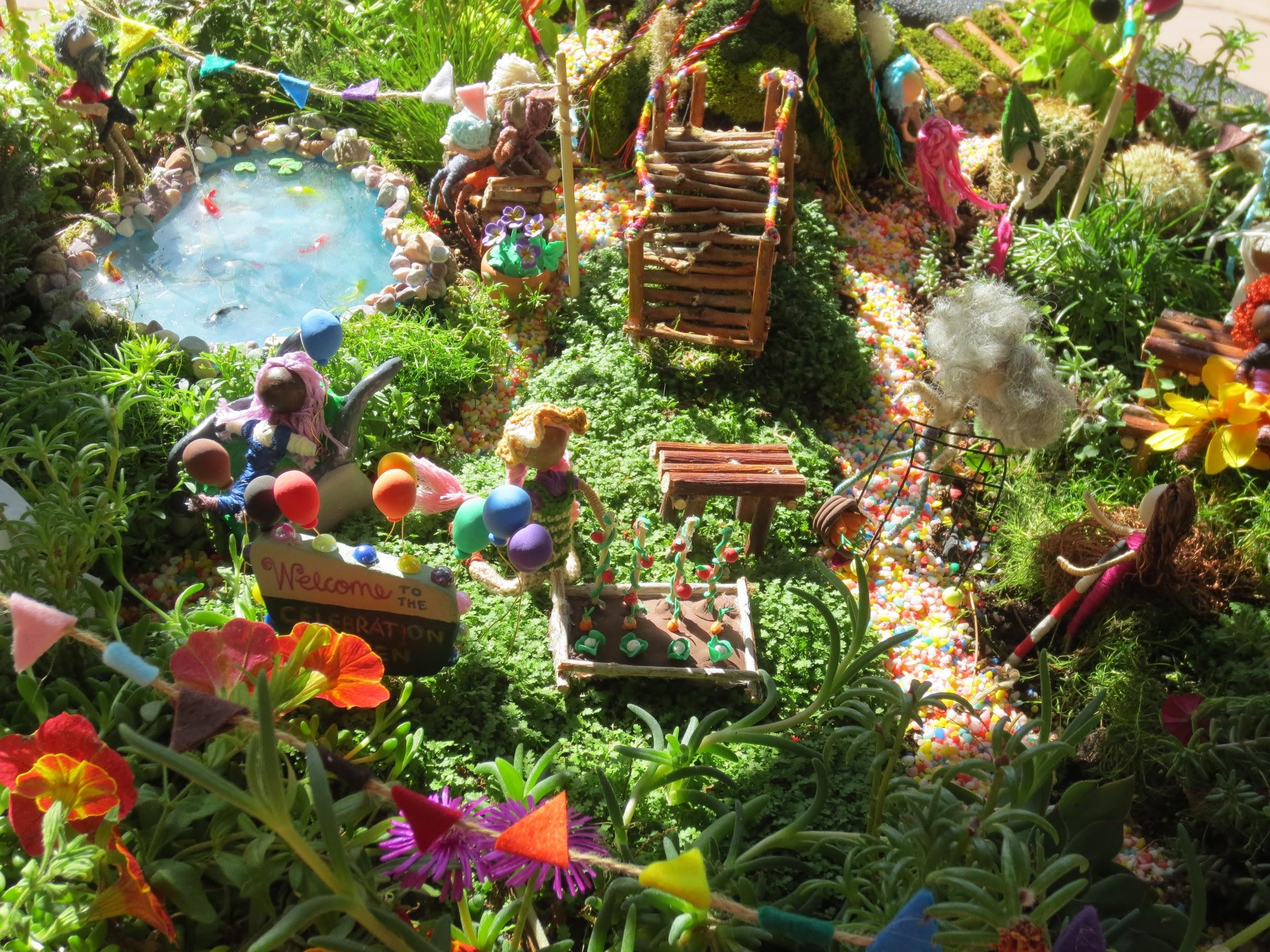 A display is pictured at Red Butte Garden's "Blooming with Pride" event, featuring a fairy-like garden with miniature figures and structures.