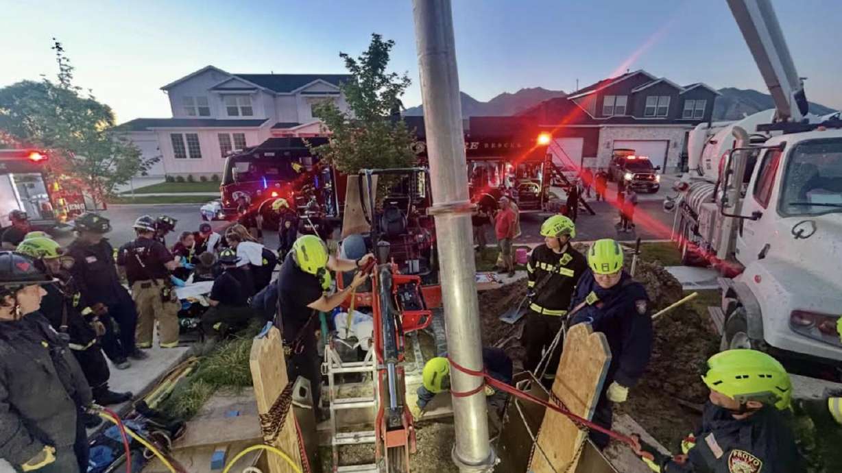 Crews rescue a man who became trapped in a trench while working at a construction site in Mapleton on Thursday.