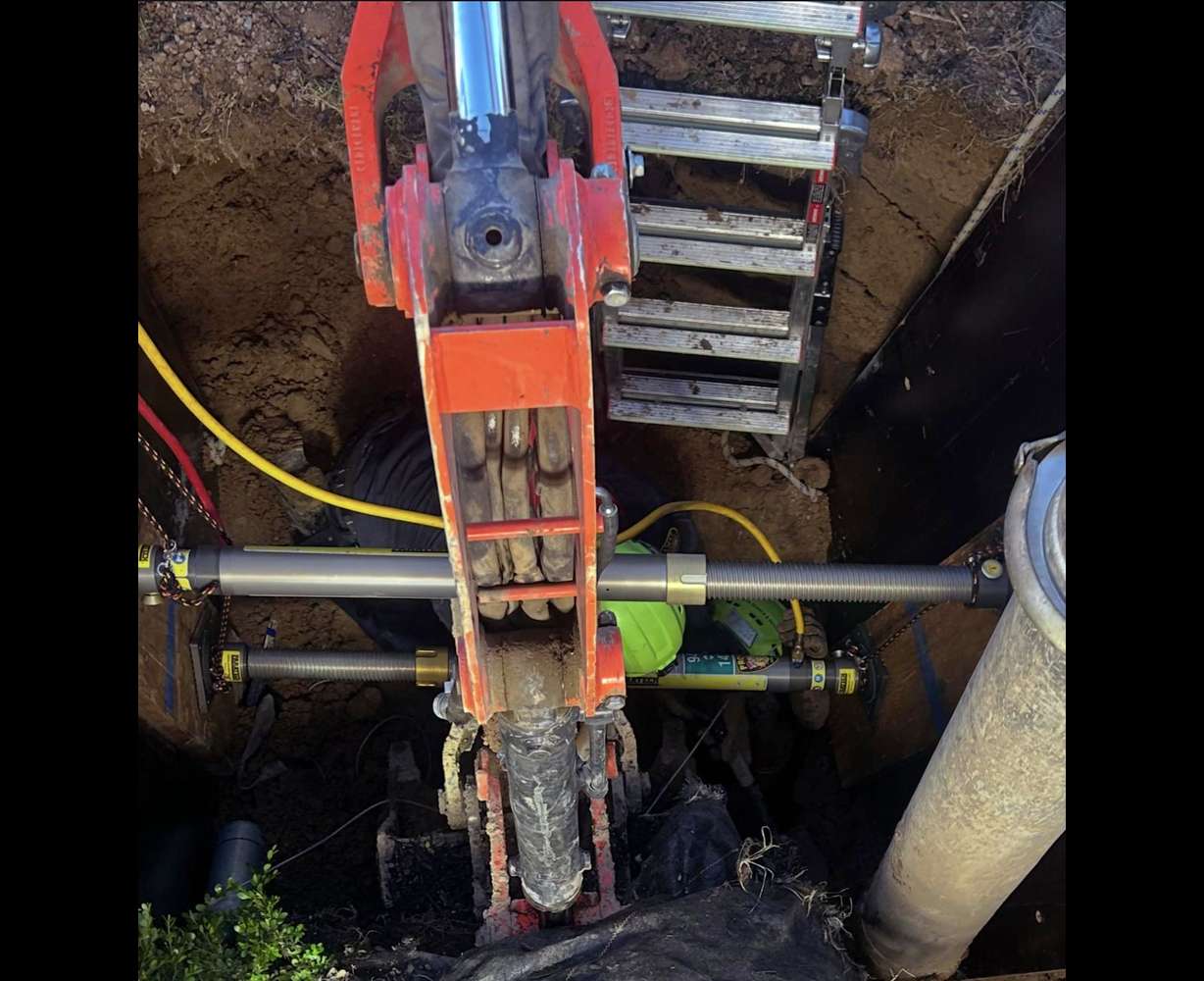 Crews rescue a man who became trapped in a trench while working at a construction site in Mapleton on Thursday.