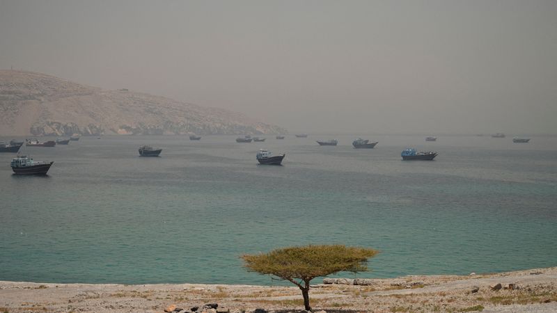 Vessels are anchored in the Strait of Hormuz, as seen from Musandam, Oman, Thursday. A purported deal to end the war in Iran, expected to be signed on Sunday by Pakistan and President Donald Trump, includes the reopening of the strait.