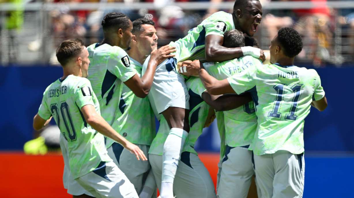 Switzerland's Breel Embolo is mobbed by teammates after scoring the opening goal from the penalty spot during the World Cup Group B soccer match between Qatar and Switzerland in Santa Clara, Calif., near San Francisco, Saturday, June 13, 2026.