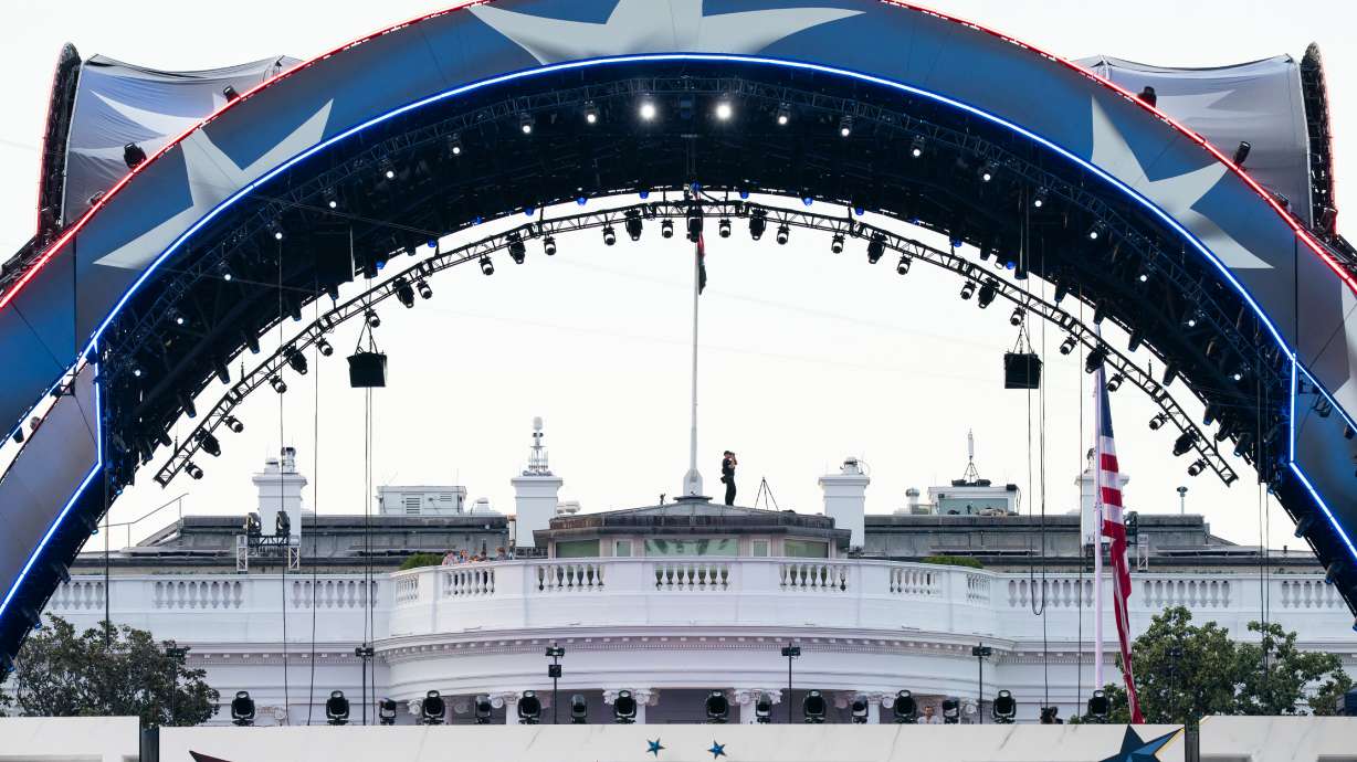 Security at the White House looks through a pair of binoculars during the UFC Fan Fest on the White House Ellipse ahead of Sunday's fight on the South Lawn, Saturday, June 13, 2026, in Washington.