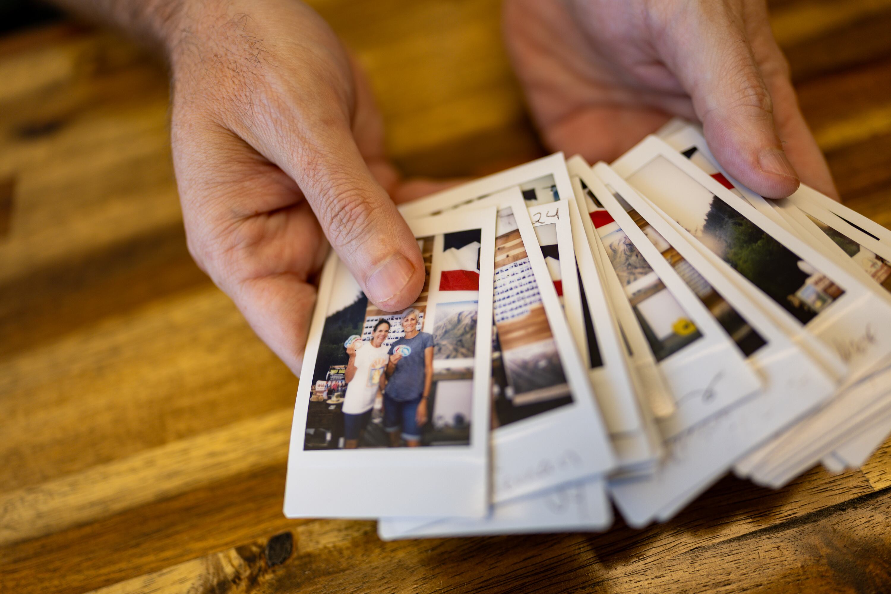 Joe Vogel, owner of Timpanogos Hiking Co., holds polaroids of people who completed the 2025 Timpanogos Hiking Challenge in his store, Timpanogos Hiking Co., in Provo on June 12. The 2026 Timpanogos Hiking Challenge is underway.