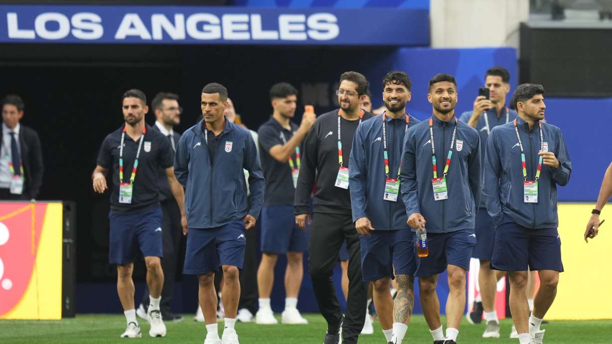 Iran players walk onto the pitch at the stadium one day before their FIFA World Cup match against New Zealand in Inglewood, Calif., near Los Angeles, Sunday. Several hundred Iranian Americans protested outside Iran's first World Cup match Monday.