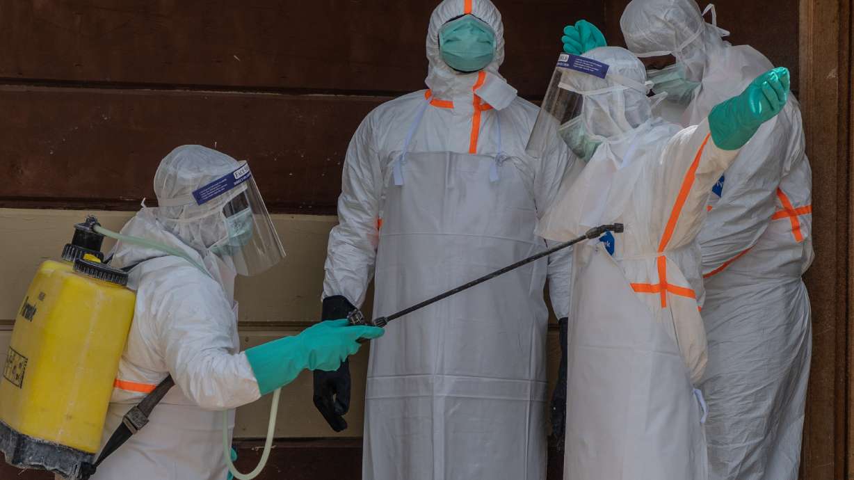 Health workers disinfect themselves after preparing the body of an Ebola victim at Citadelle Clinic in Bunia, Congo, Friday.