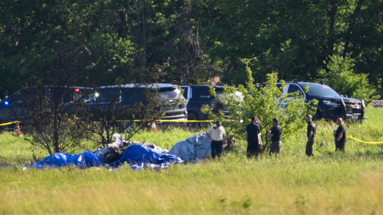 Emergency personnel investigate the site of a plane crash at the Butler Memorial Airport in Butler, Mo., Sunday. Several of the skydivers who were killed were experienced jumpers.