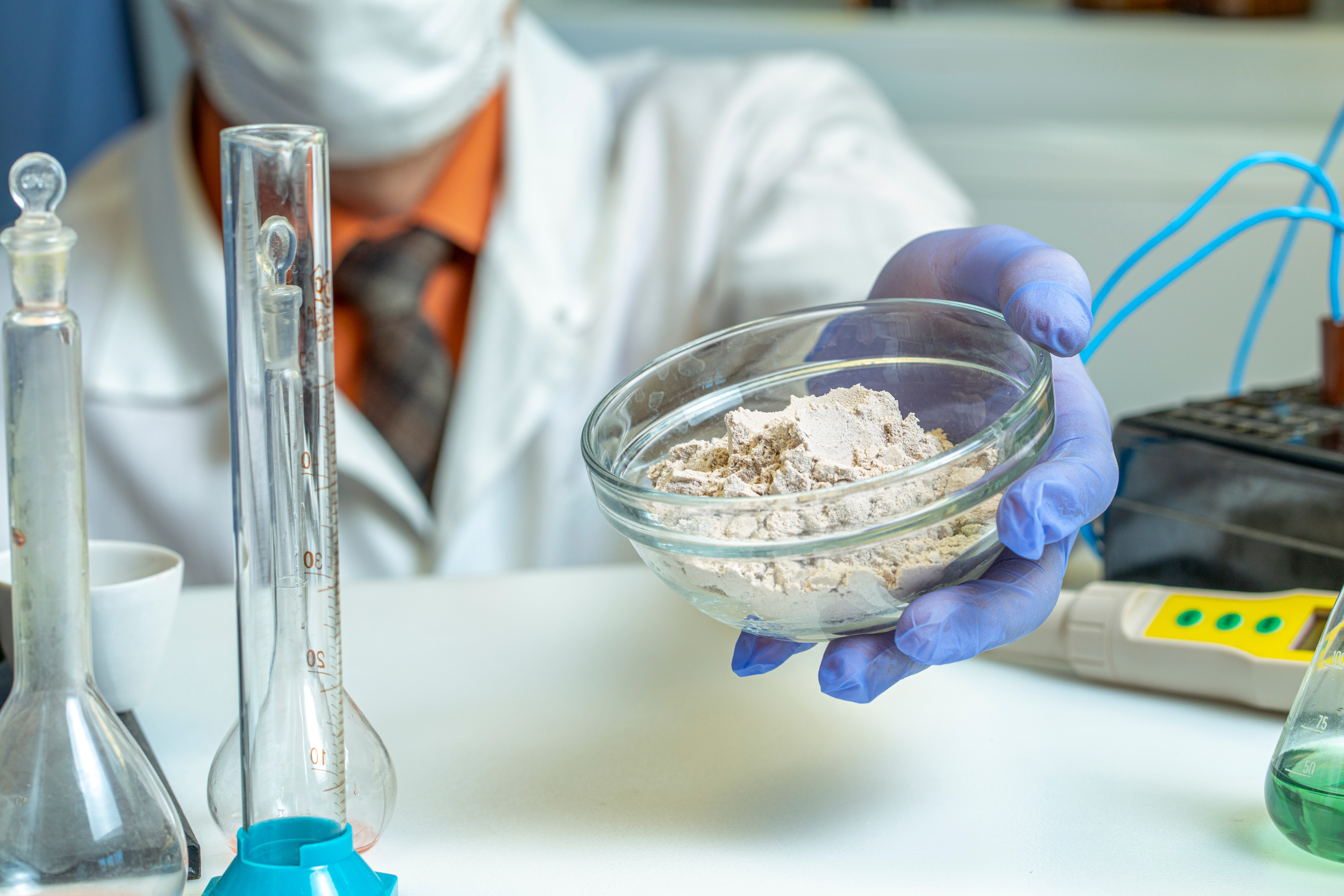 Analysis of sports nutrition in the laboratory. The inspector is holding a whey protein in his hand. Close up.