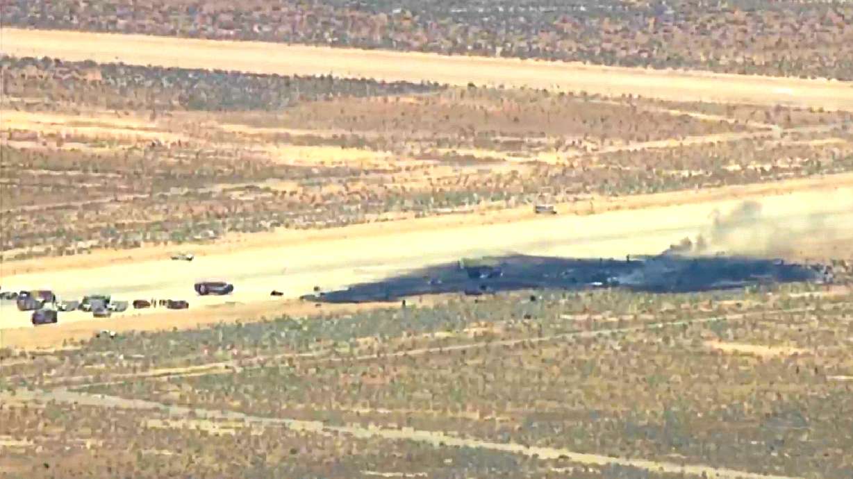 This image taken from video provided by KABC shows law enforcement responding to the scene of an aircraft crash, Monday, near Edwards Air Force Base, Calif. Officials say a B-52 bomber crashed shortly after takeoff.
