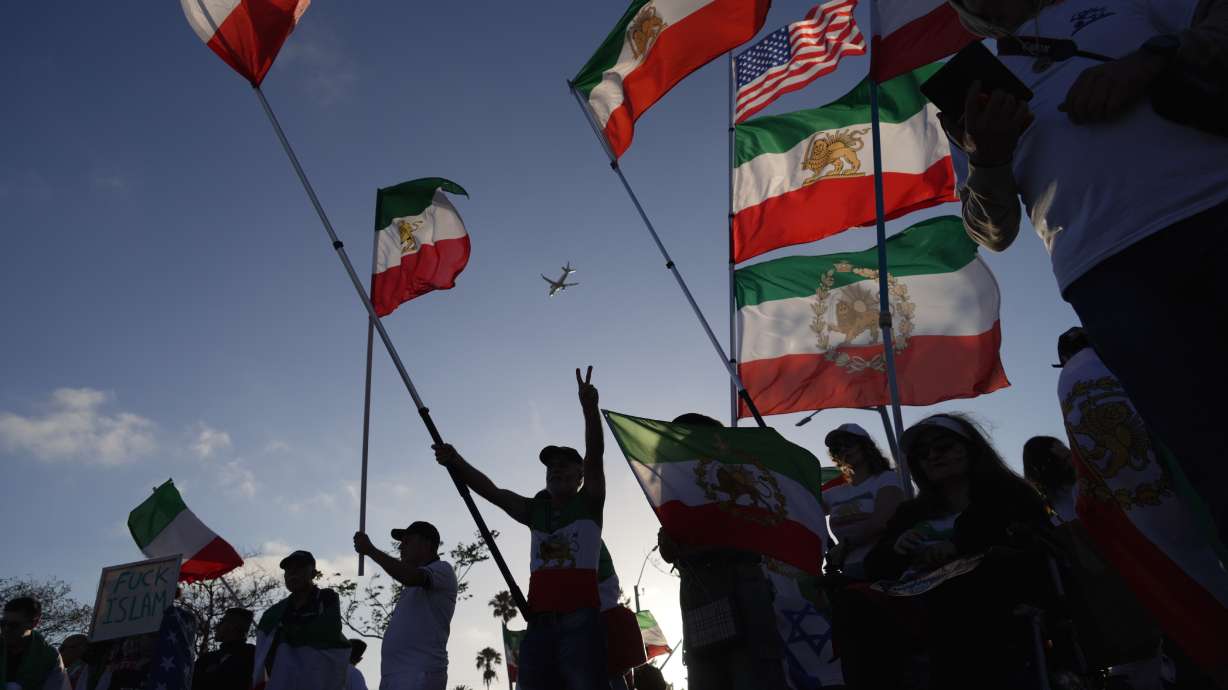 People wave pre-revolutionary Iranian flags during a protest outside Los Angeles Stadium before the World Cup Group G soccer match between Iran and New Zealand in Inglewood, Calif., near Los Angeles, Monday, June 15, 2026.