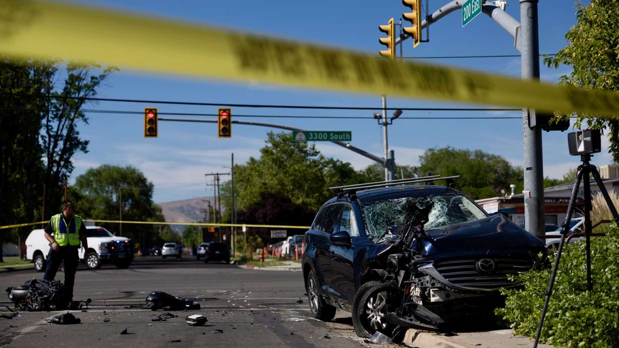 Police officers work the scene after a fatal collision between a car and a motorcycle on 3300 South at 200 East in South Salt Lake on Tuesday.