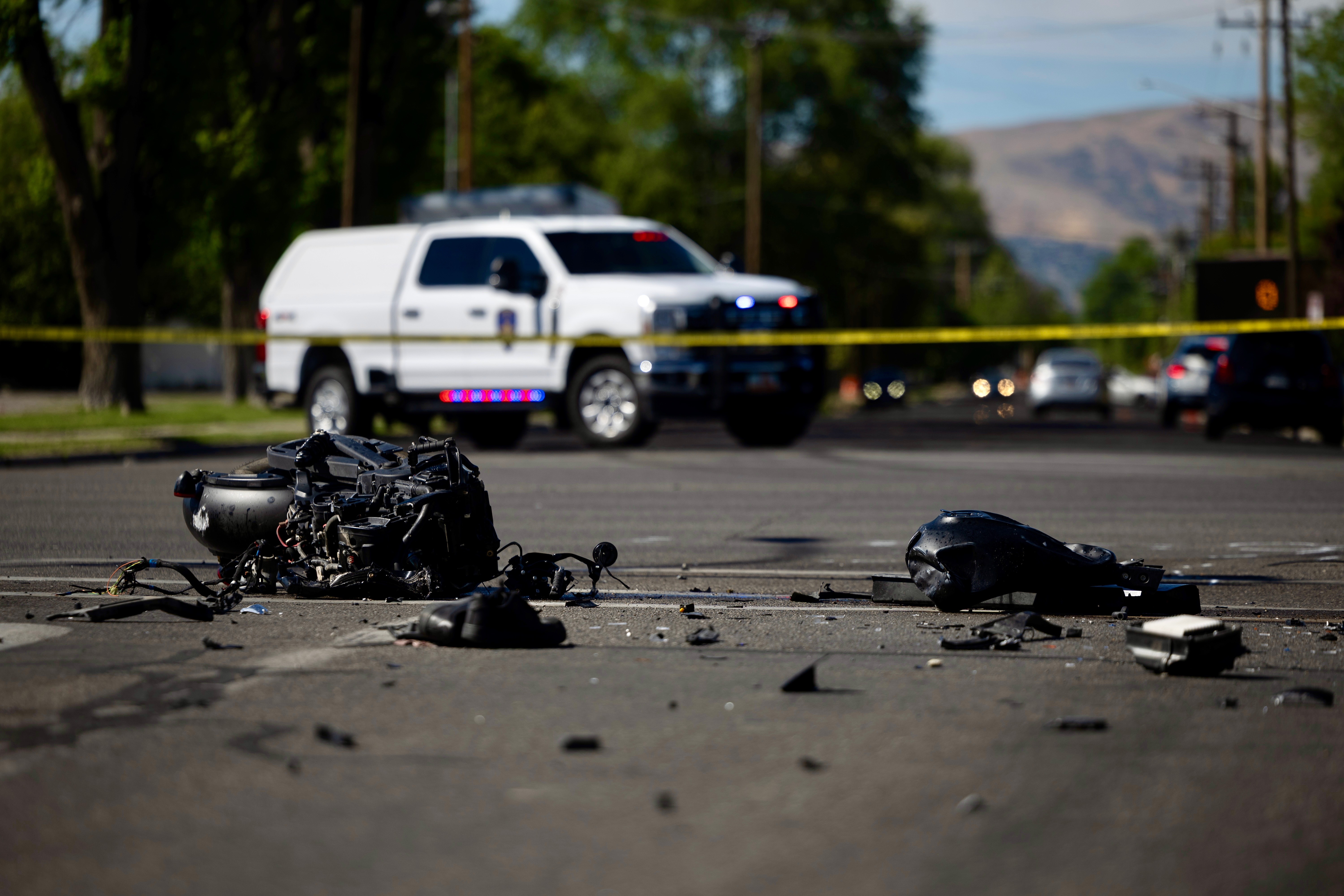 Police officers work the scene after a fatal collision between a car and a motorcycle on 3300 South at 200 East in South Salt Lake on Tuesday.