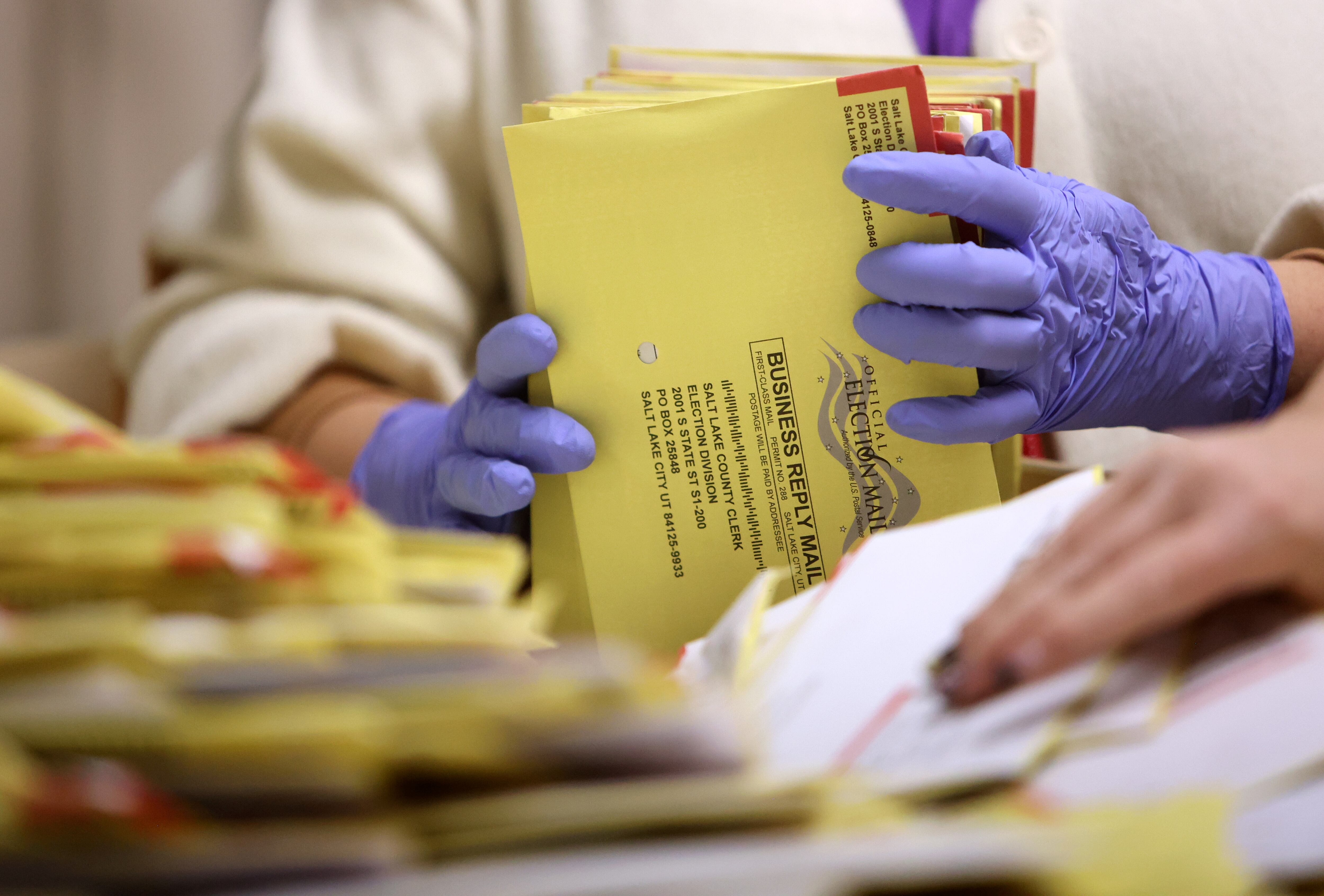A temporary election worker gathers ballots to process at the Salt Lake County Government Center in Salt Lake City on Oct. 31, 2024. Voter turnout is already high for this year's elections in the primaries alone.