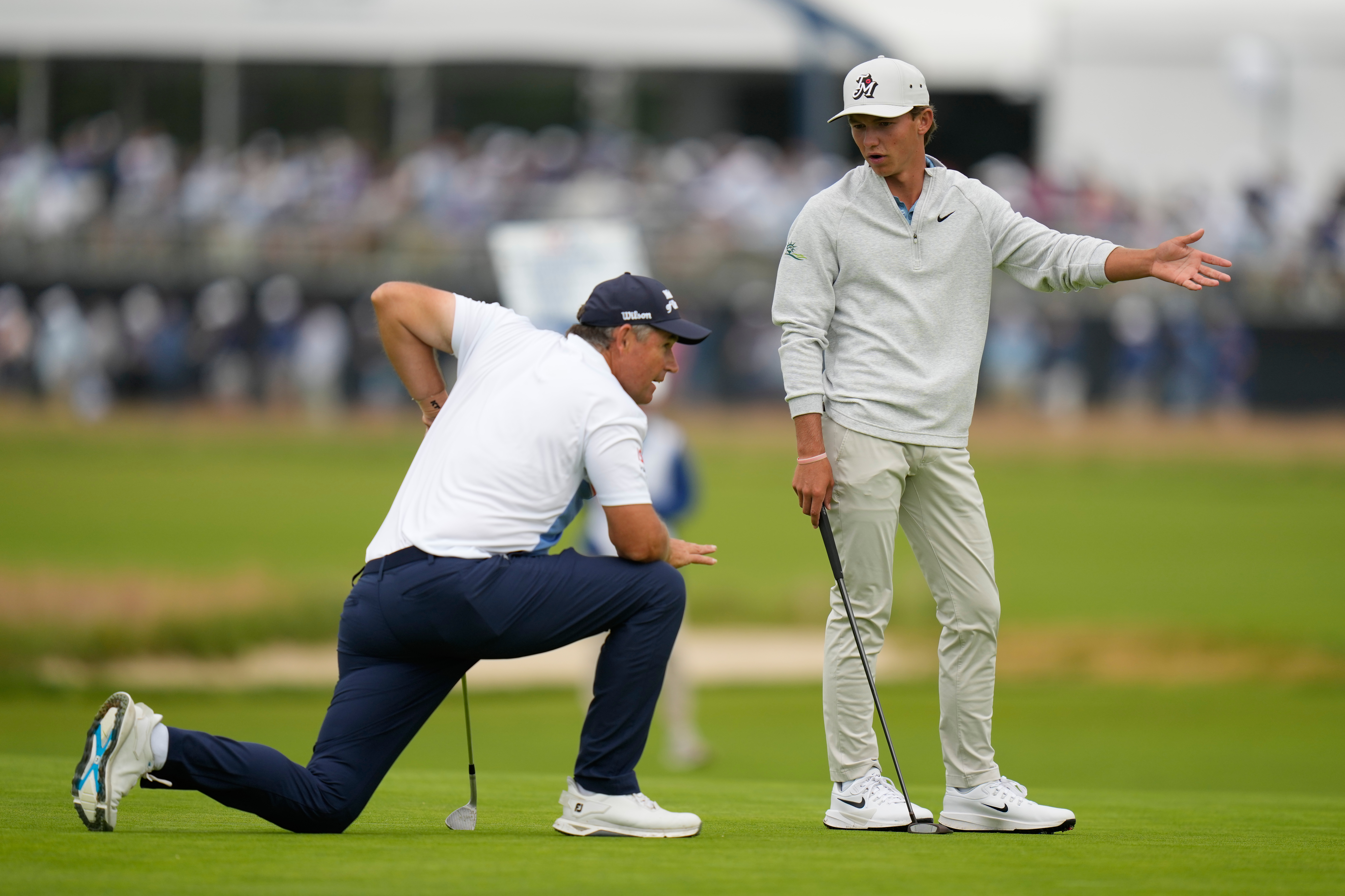 Miles Russell and Padraig Harrington, of Ireland, talk on the fourth hole during the first round of the U.S. Open golf tournament at Shinnecock Hills Golf Club in Southampton, N.Y., Thursday, June 18, 2026.