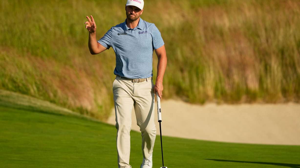 Wyndham Clark waves after his putt on the 18th hole during the first round of the U.S. Open golf tournament at Shinnecock Hills Golf Club in Southampton, N.Y., Thursday, June 18, 2026.