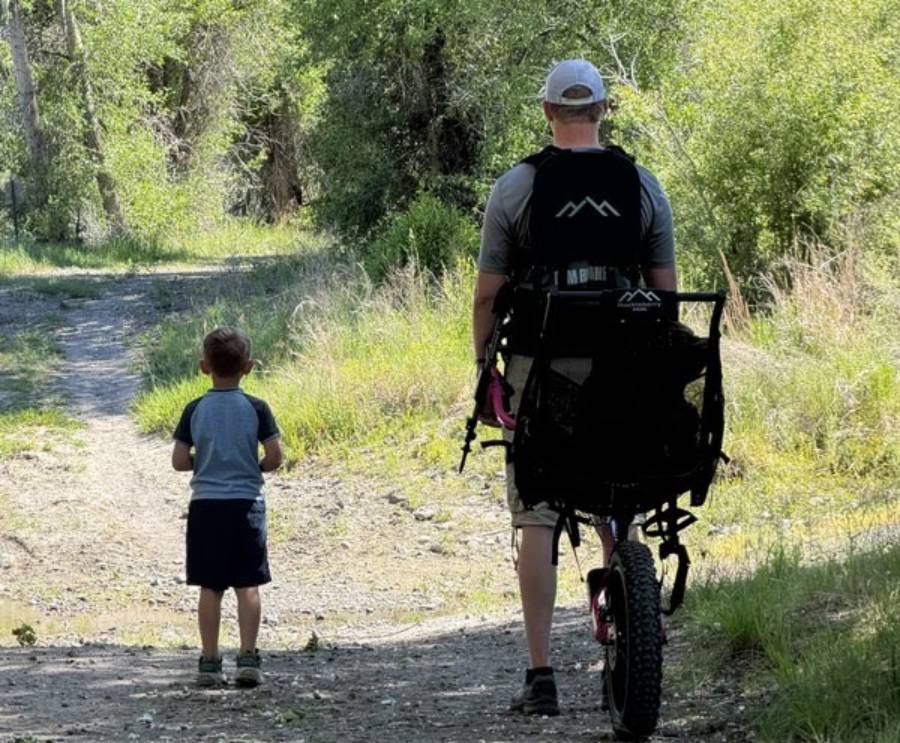Jonathan Goodsell pulls a Huckleberry Hiking chair with Hailey in it alongside her brother Jacob at Beaver Dick Park in Madison County, Idaho.