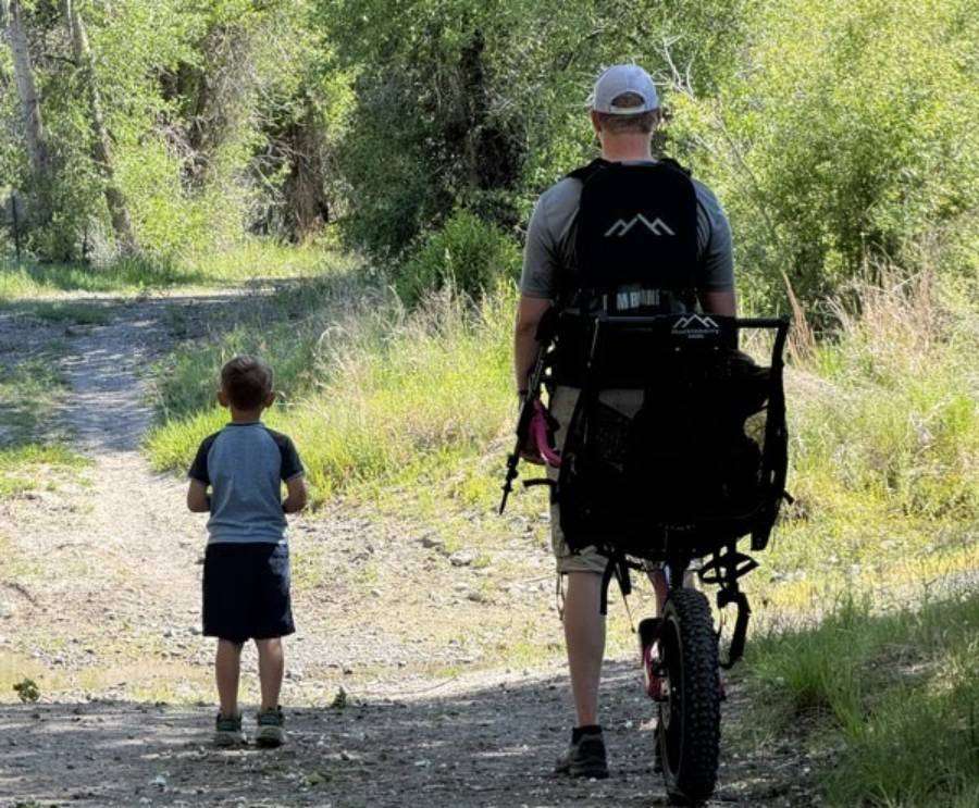 Jonathan Goodsell pulls a Huckleberry Hiking chair with Hailey in it alongside her brother Jacob at Beaver Dick Park in Madison County, Idaho.