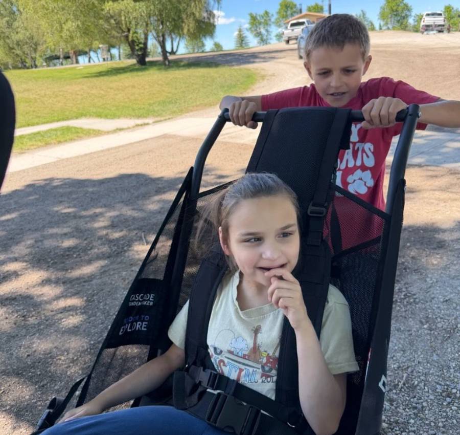 Jackson Goodsell pushes his sister Hailey in her new Huckleberry Hiking outdoor mobility chair at Beaver Dick Park in Madison County, Idaho.