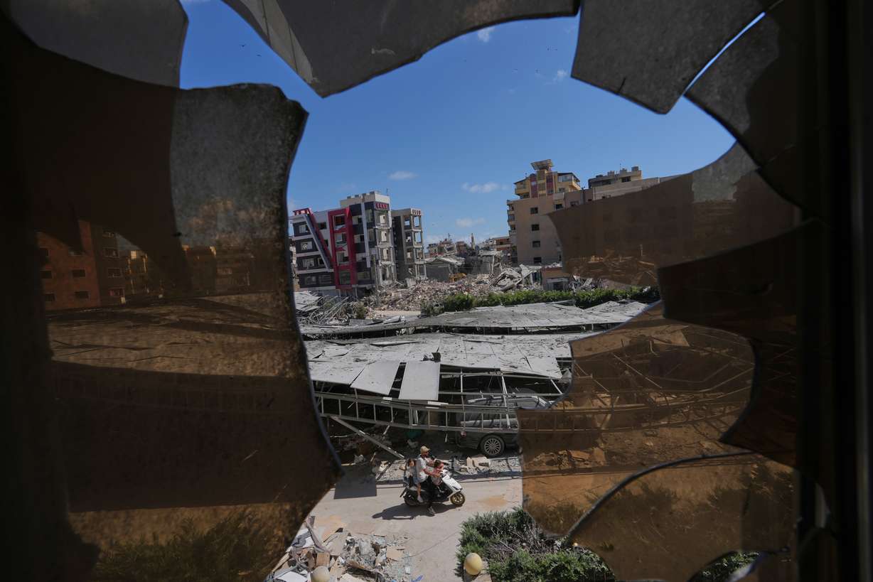 Buildings damaged by Israeli strikes are seen through shattered glass from the Jabal Amel Hospital in the southern port city of Tyre, Lebanon, Thursday. Increased fighting in Lebanon has threatened an interim agreement to end the war in Iran.