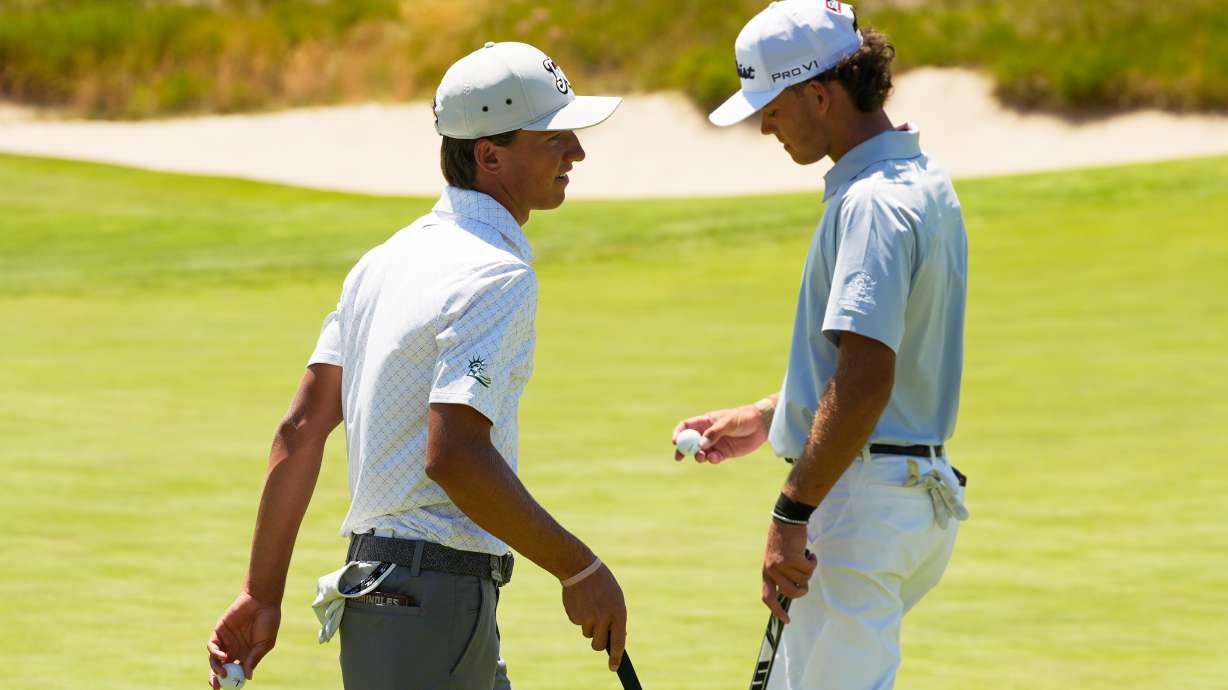 Miles Russell and Jackson Koivu walk on the 14th hole during the third round of the U.S. Open golf tournament at Shinnecock Hills Golf Club in Southampton, N.Y., Saturday, June 20, 2026.